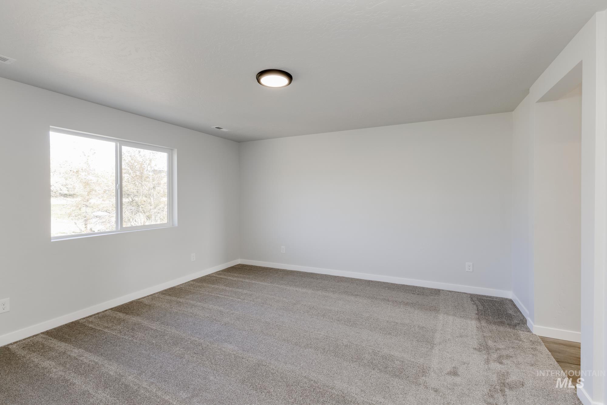 Spare room with light carpet and baseboards