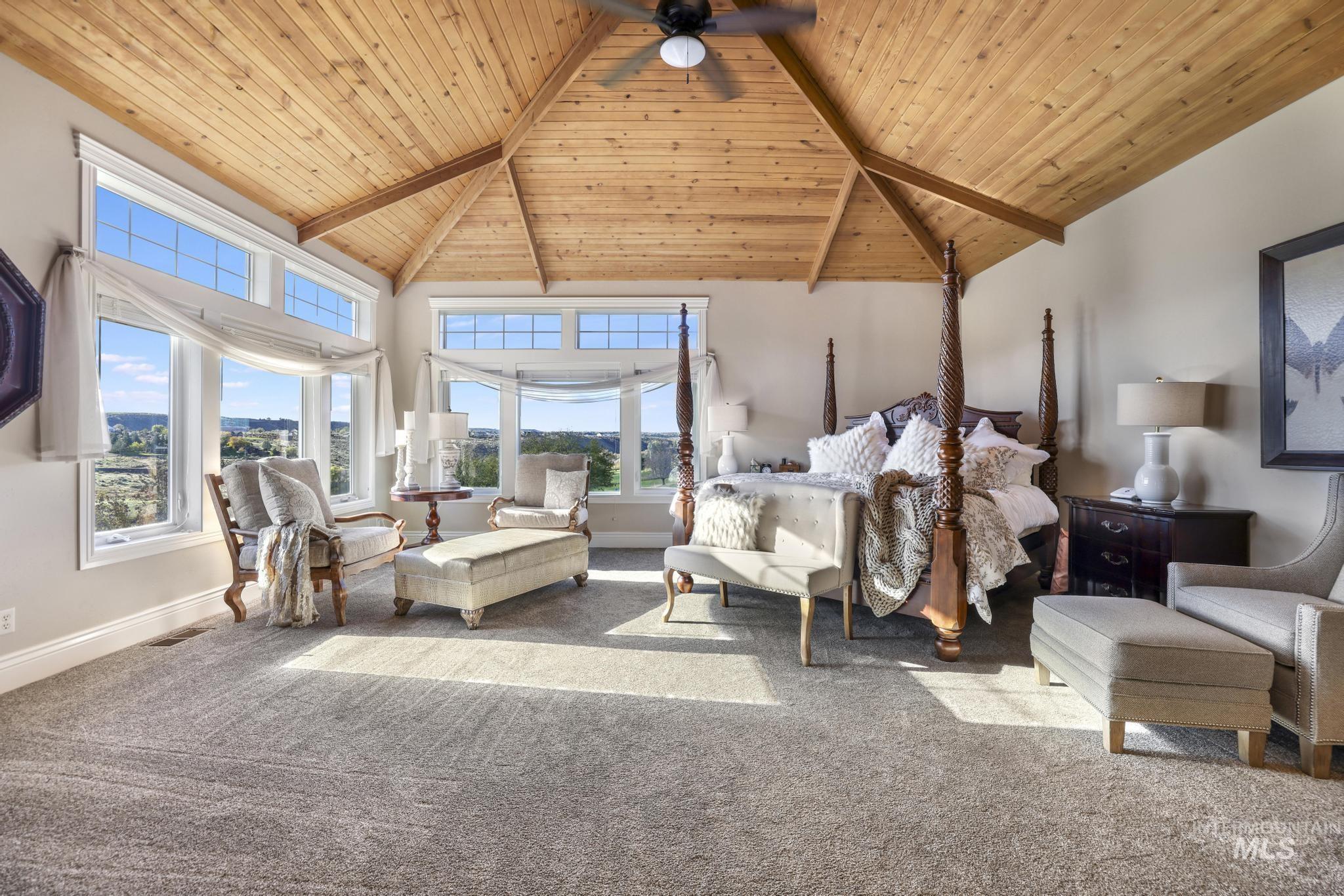 Carpeted bedroom with high vaulted ceiling, a wood ceiling with exposed beams, and a ceiling fan