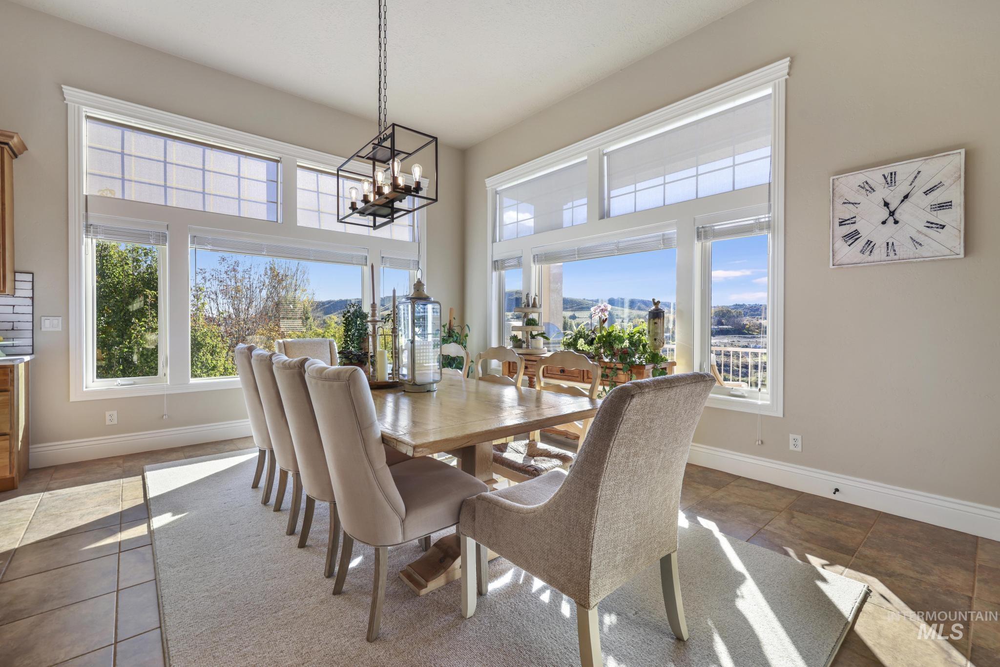 Tiled dining room with healthy amount of natural light and a chandelier