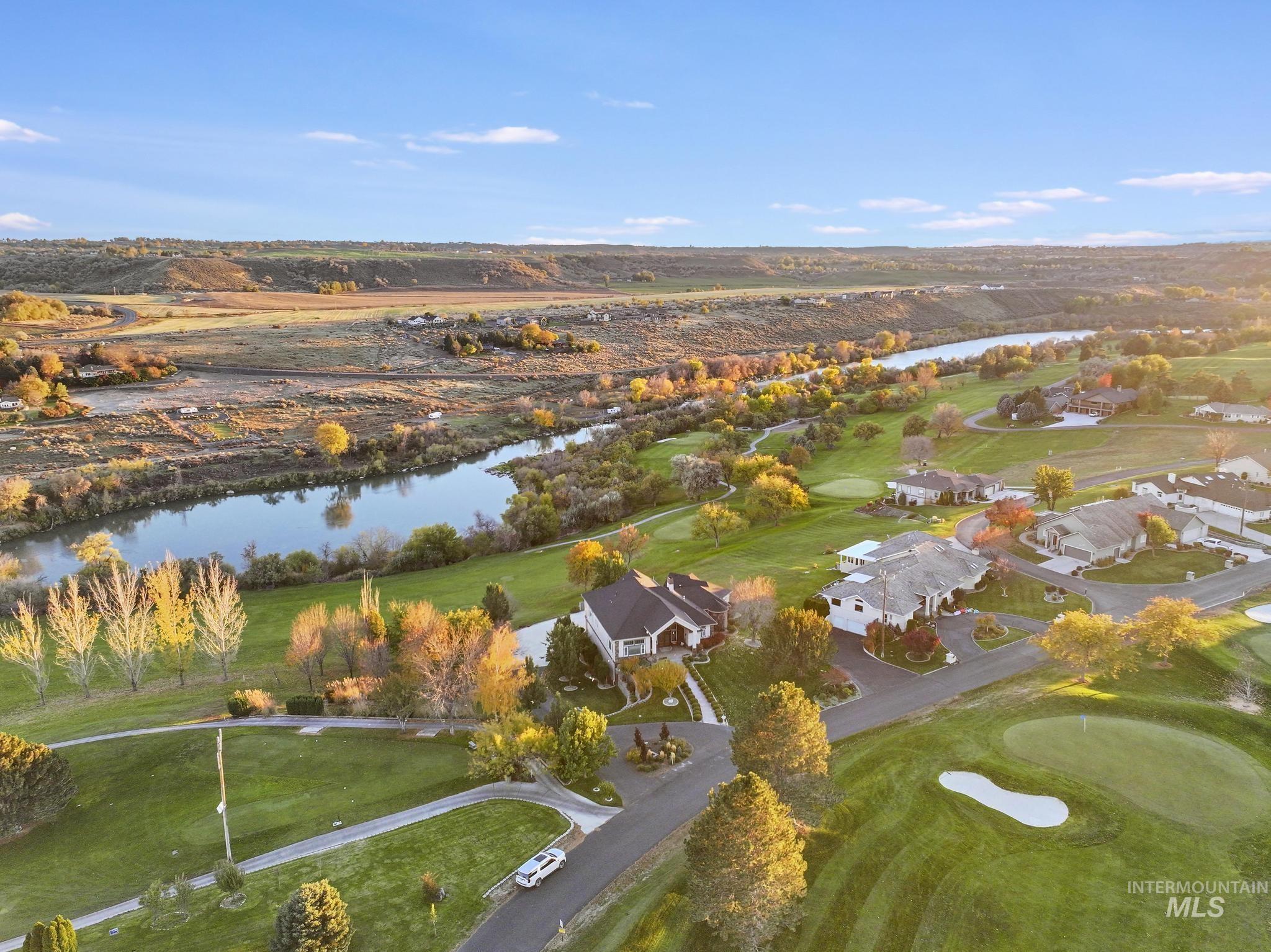 Aerial view of property's location featuring a large body of water and a local golf course