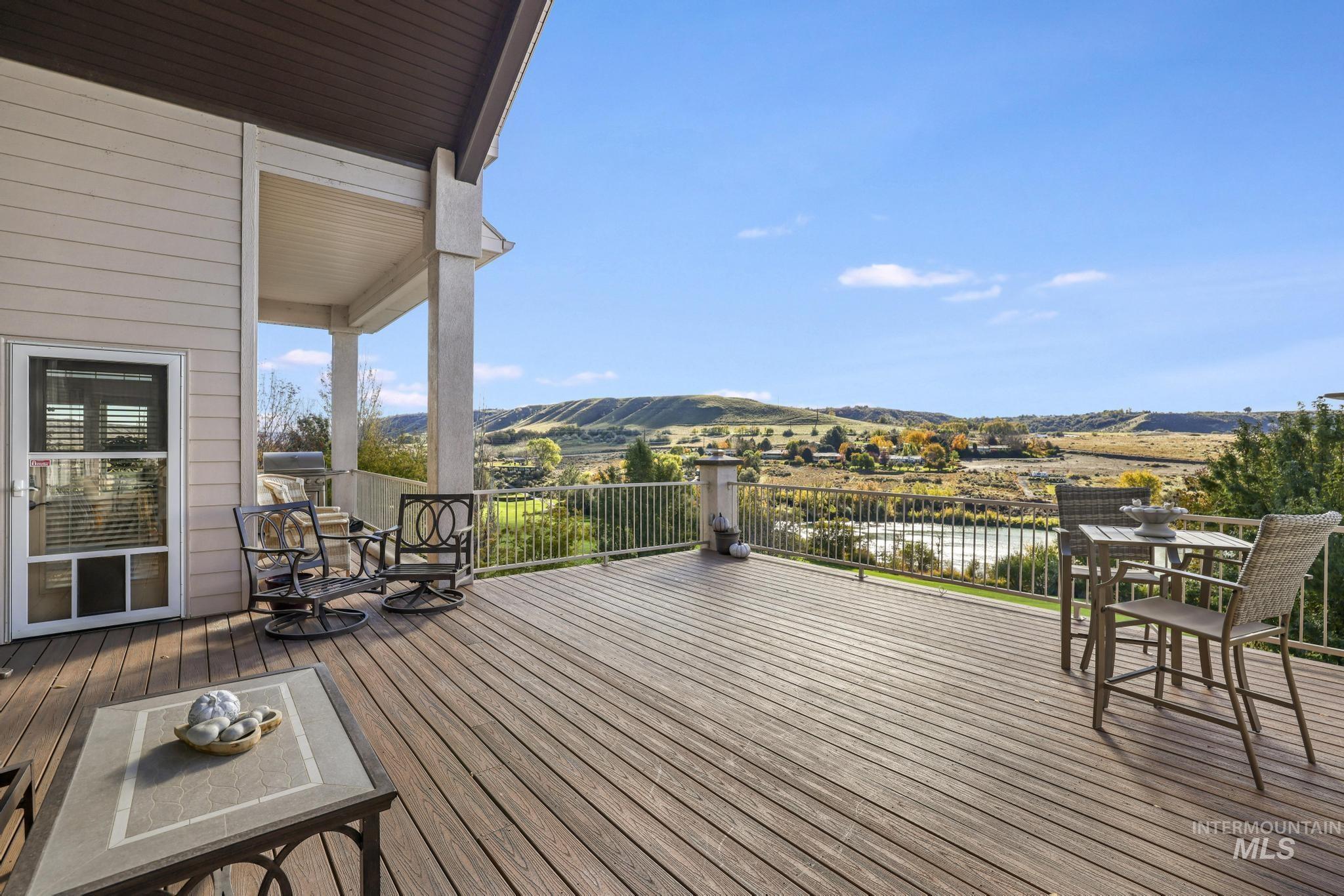 Wooden deck with a water view and outdoor dining space