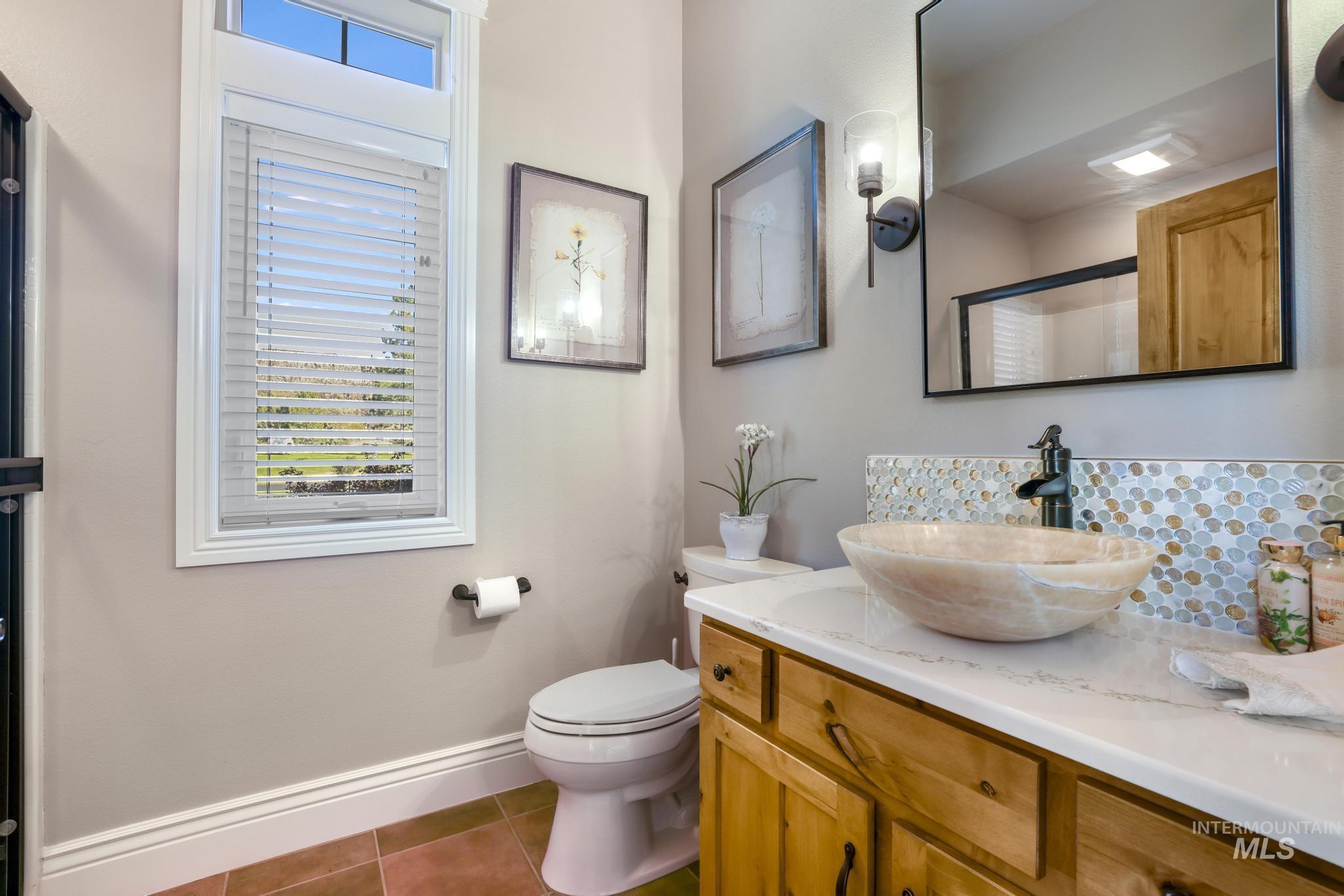Full bath with vanity, dark tile patterned floors, and an enclosed shower