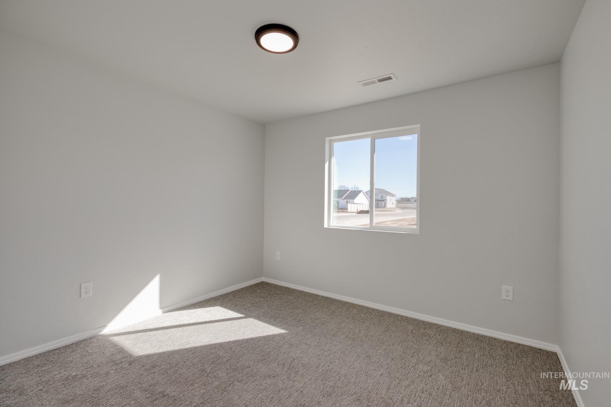 Carpeted empty room featuring baseboards