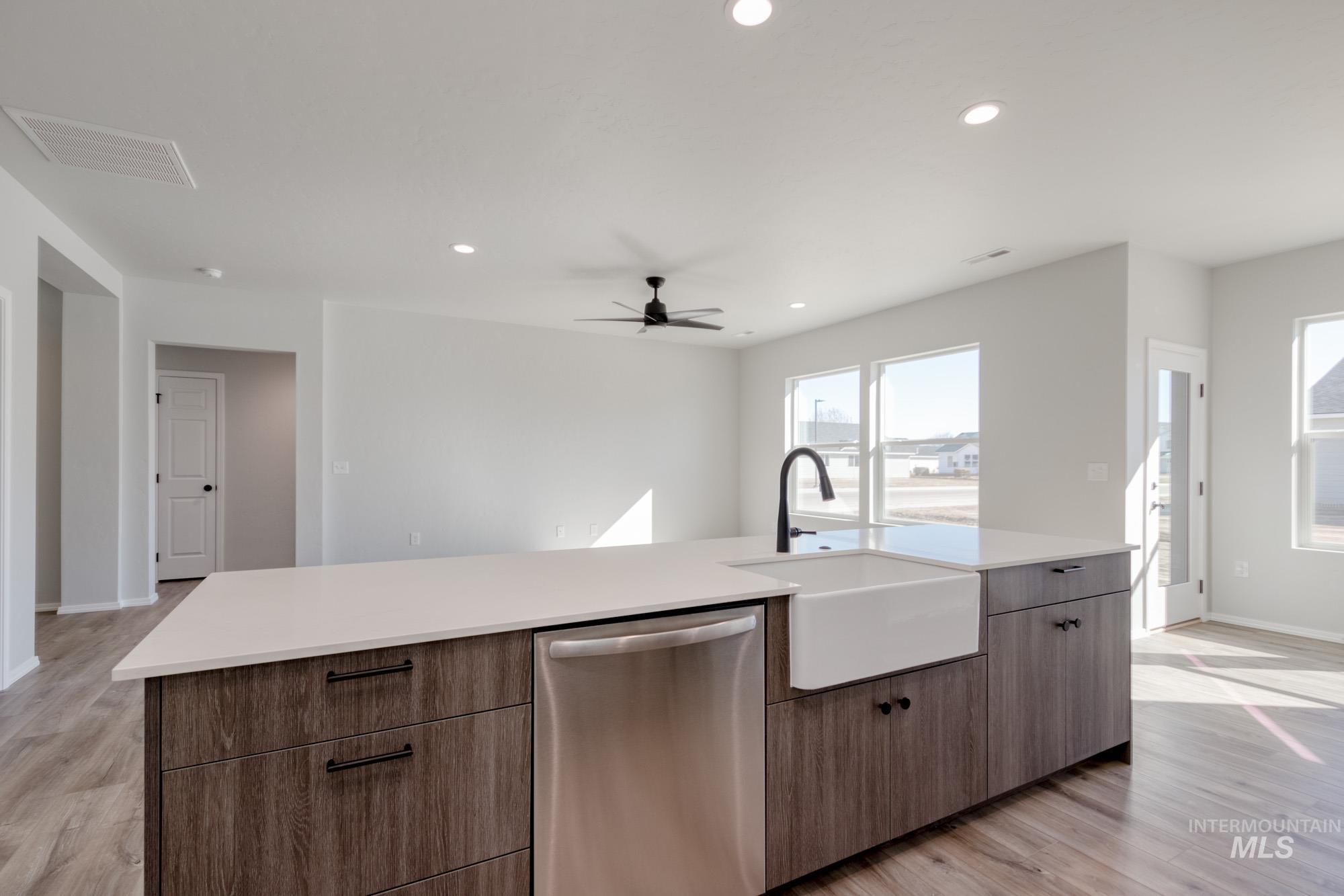Kitchen with stainless steel dishwasher, light wood-type flooring, recessed lighting, ceiling fan, and open floor plan