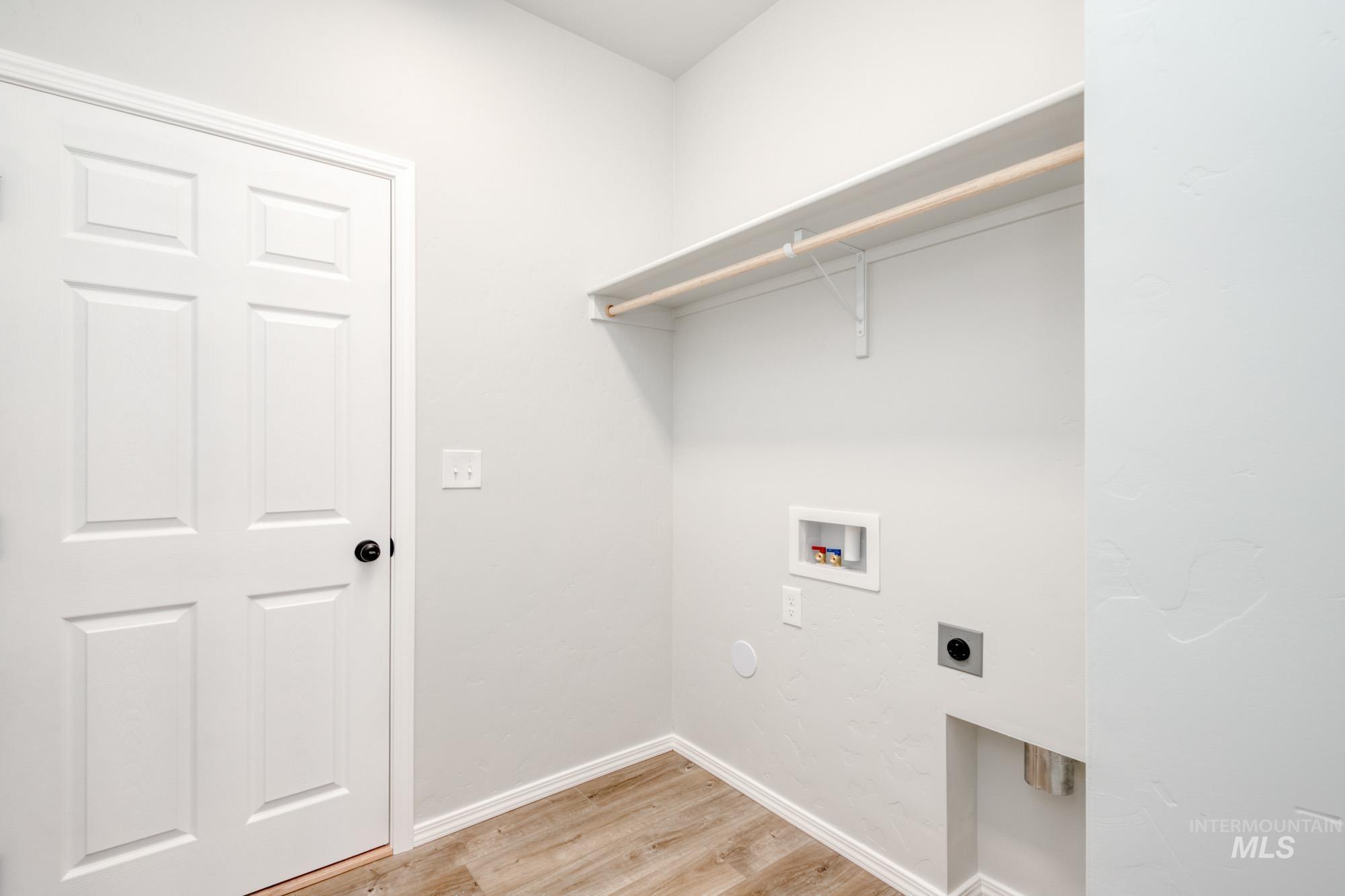 Laundry room featuring light wood-style floors, hookup for a washing machine, and electric dryer hookup