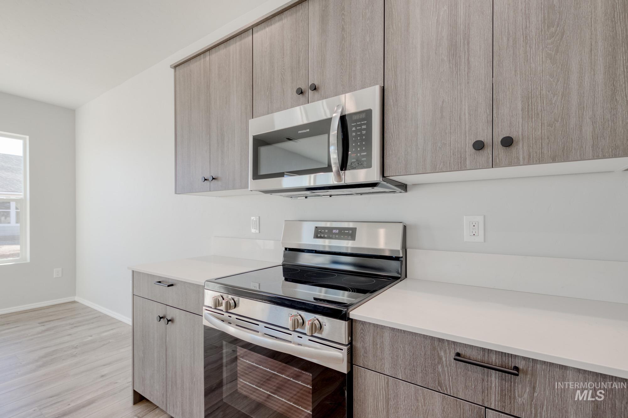 Kitchen featuring stainless steel appliances, light brown cabinetry, and modern cabinets