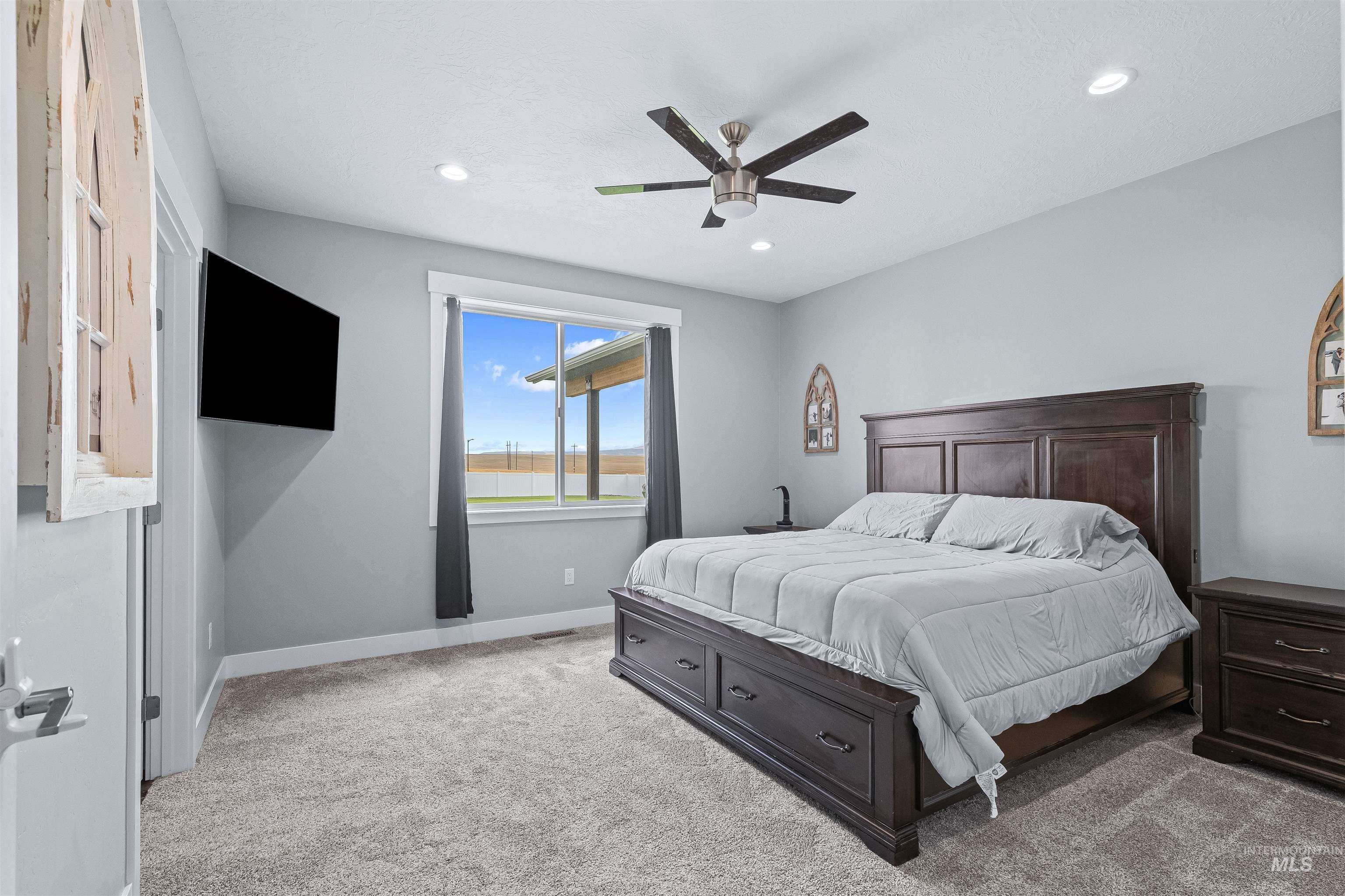 Carpeted bedroom featuring a ceiling fan and recessed lighting