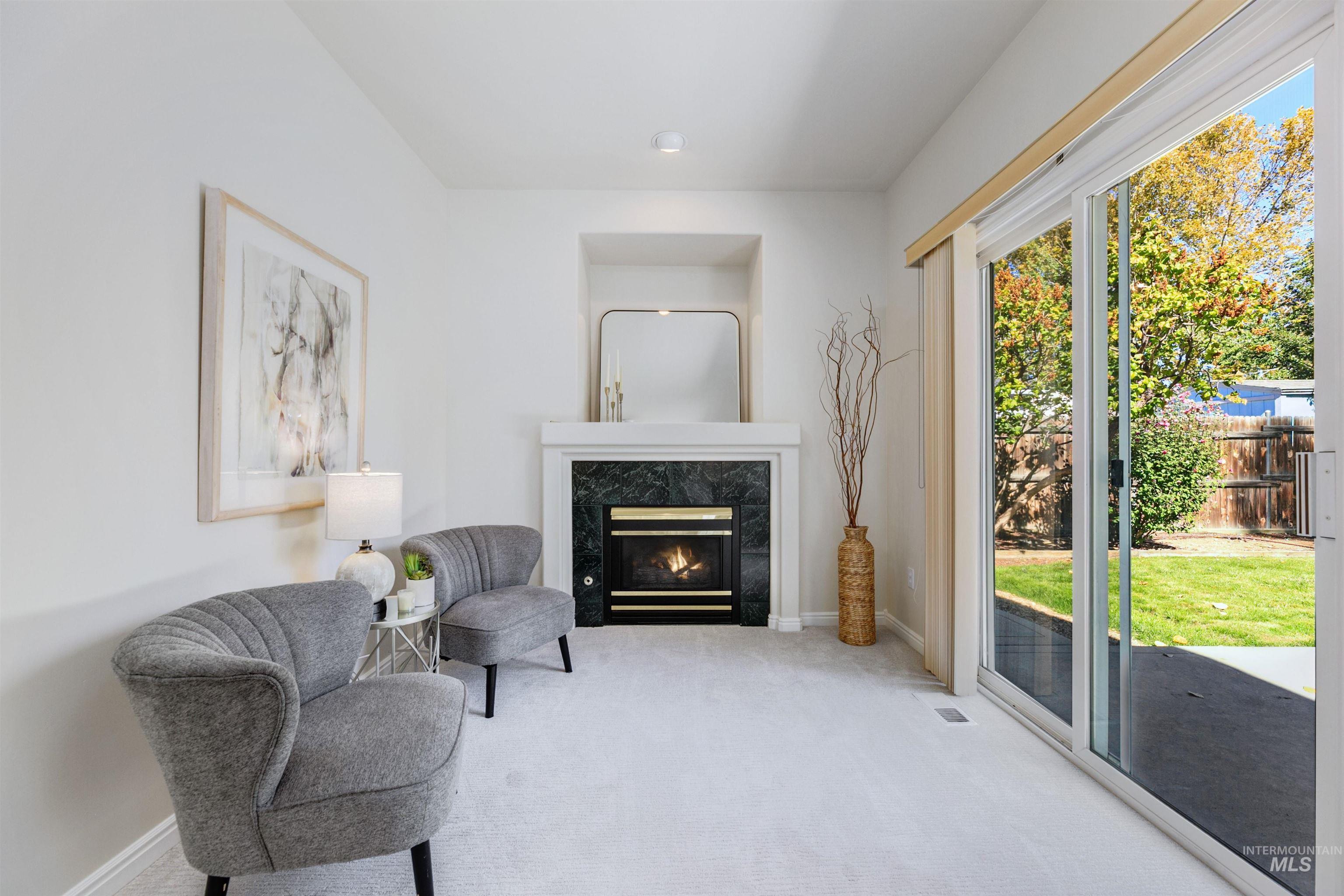 Sitting room with carpet flooring and a premium fireplace