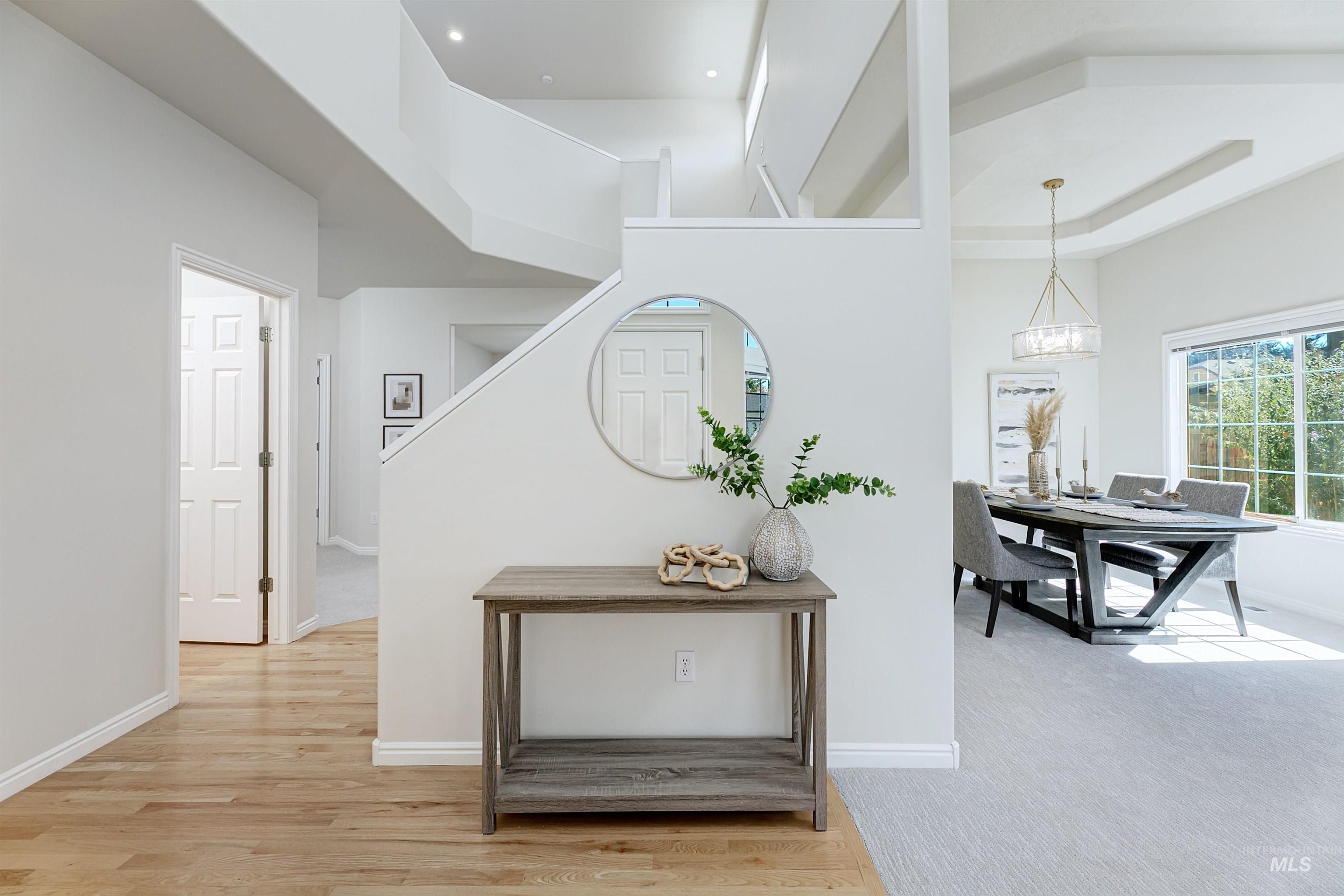 Hallway featuring light wood finished floors and a high ceiling