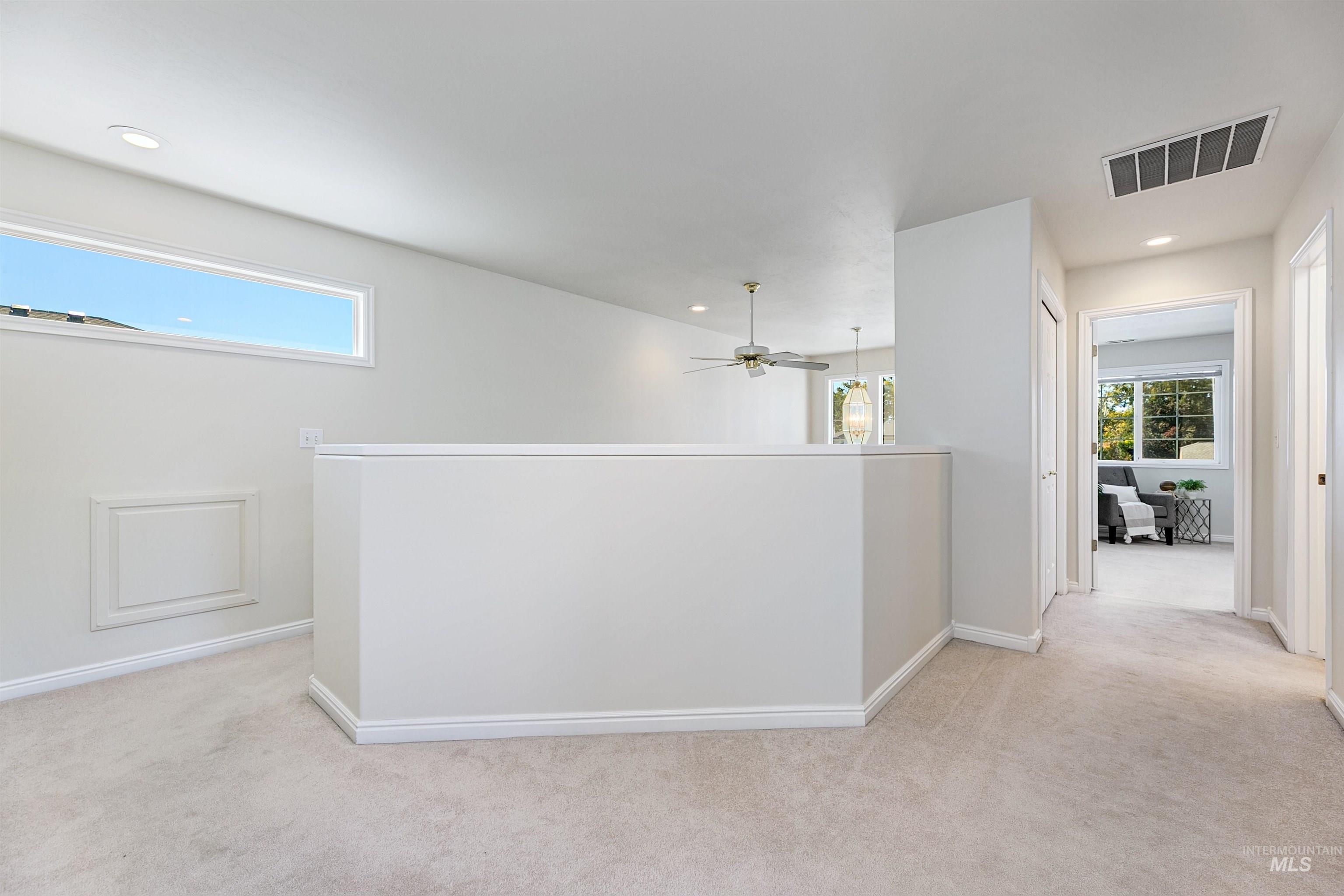 Hall featuring light carpet, recessed lighting, and an upstairs landing