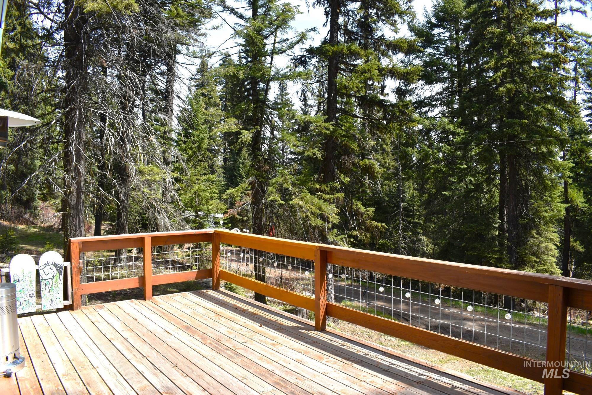 Spacious outdoor deck with natural wood flooring and a modern wood railing featuring wire mesh infill