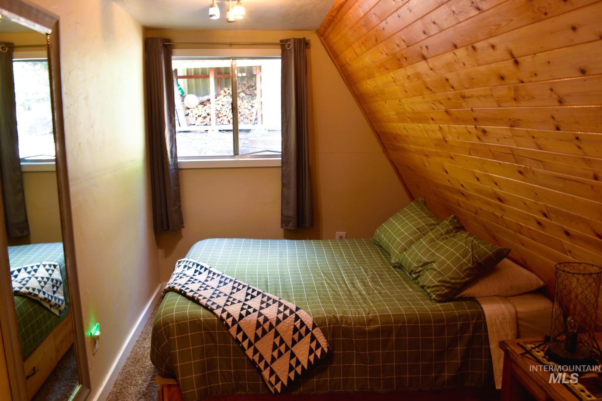 Wood-paneled accent wall with a sloped ceiling