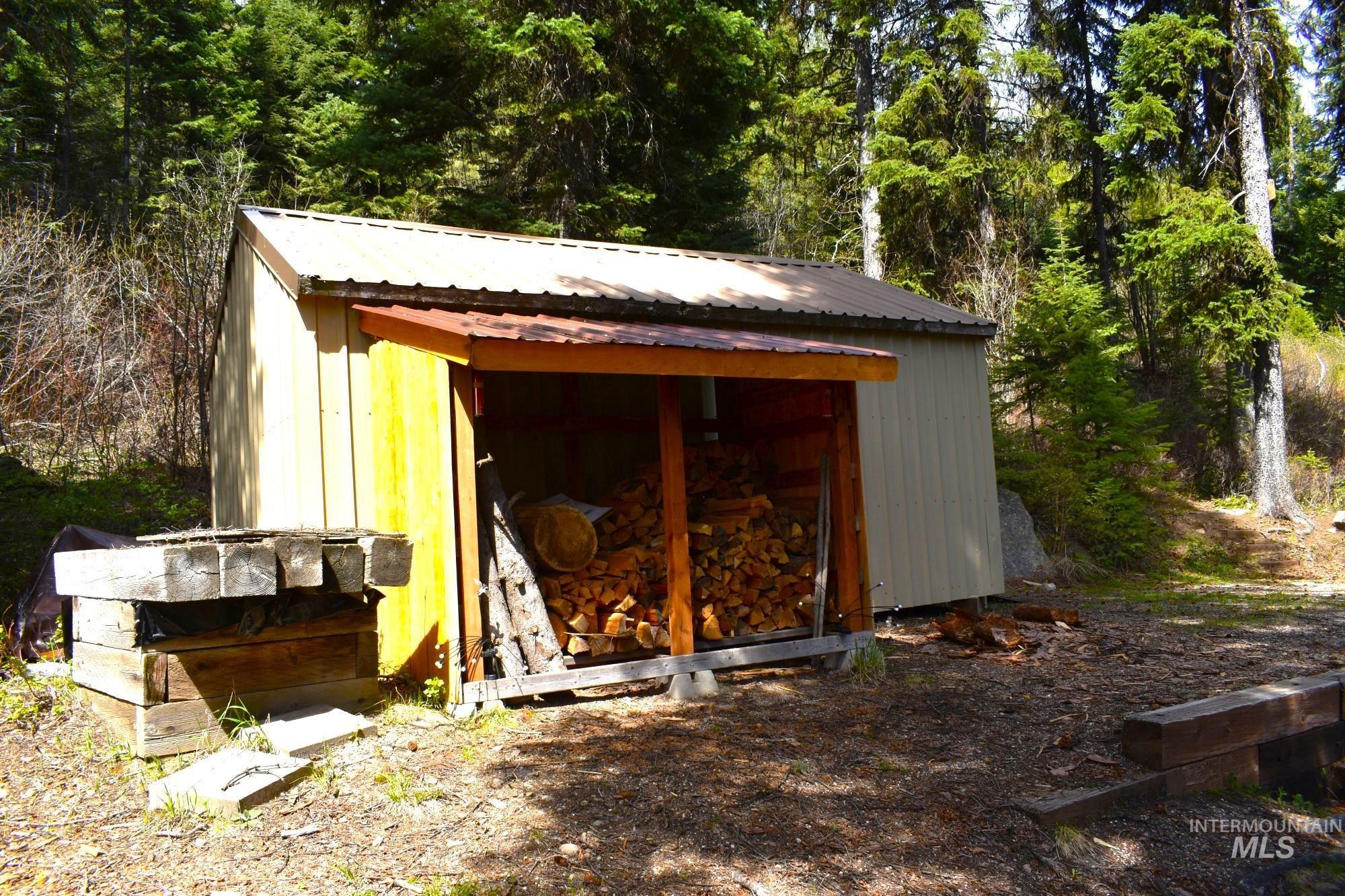 Utility shed with tan siding and a metal roof