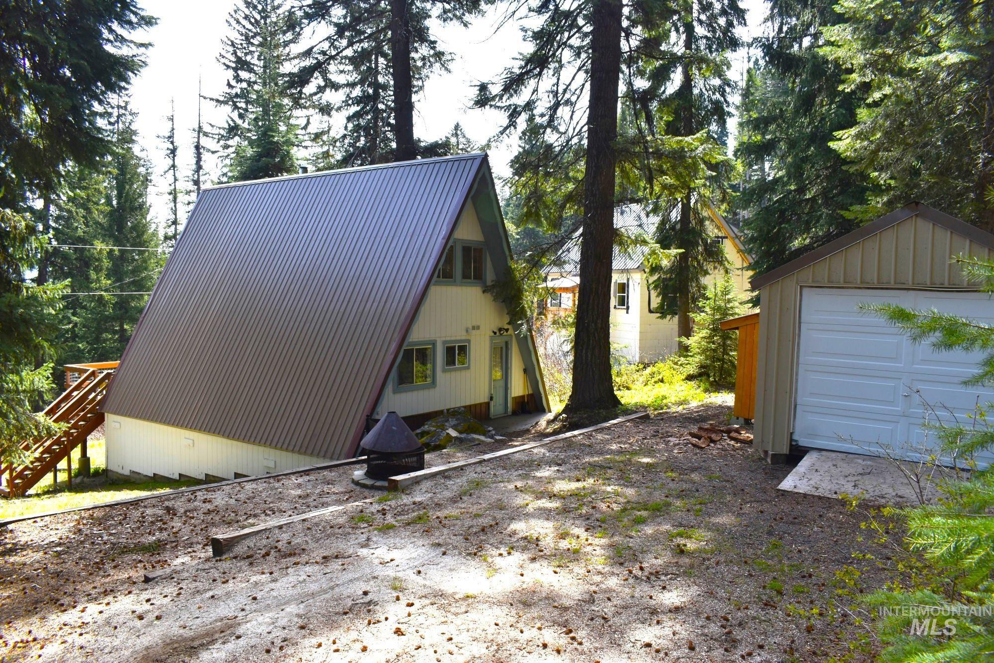 A-frame structure featuring a metal roof and light-colored siding