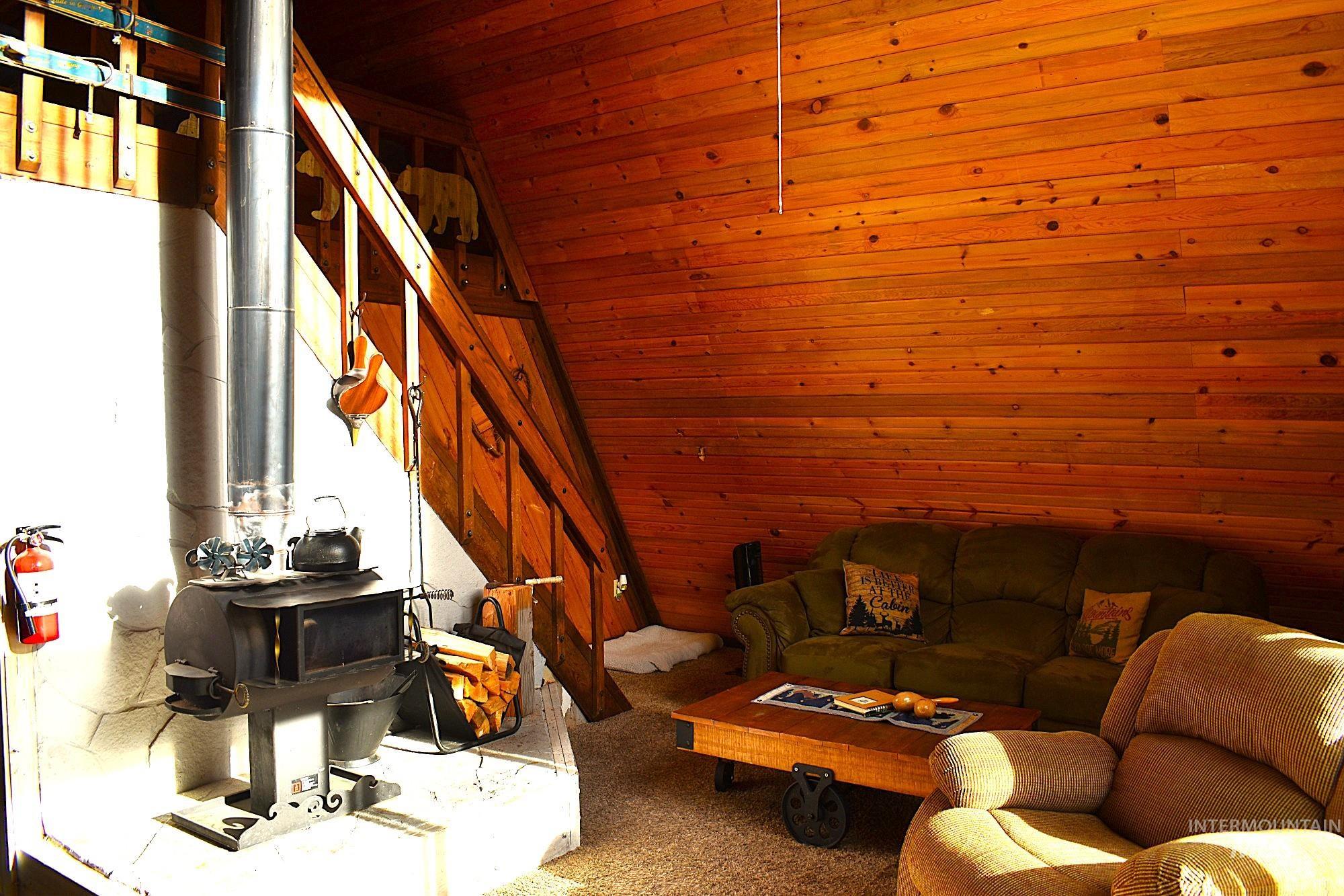 Interior featuring wood-paneled walls and a wood-burning stove with a stone base