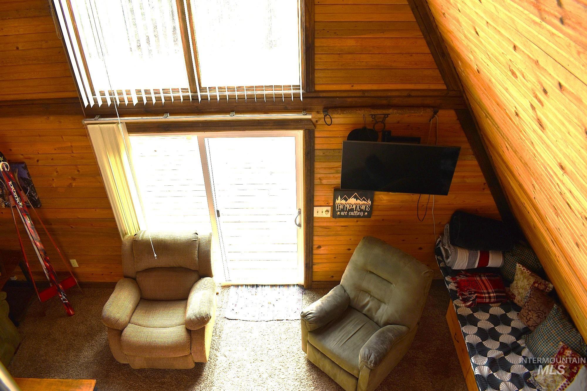 Vaulted wood-paneled ceiling with exposed beams, illuminated by large skylights and a sliding glass door