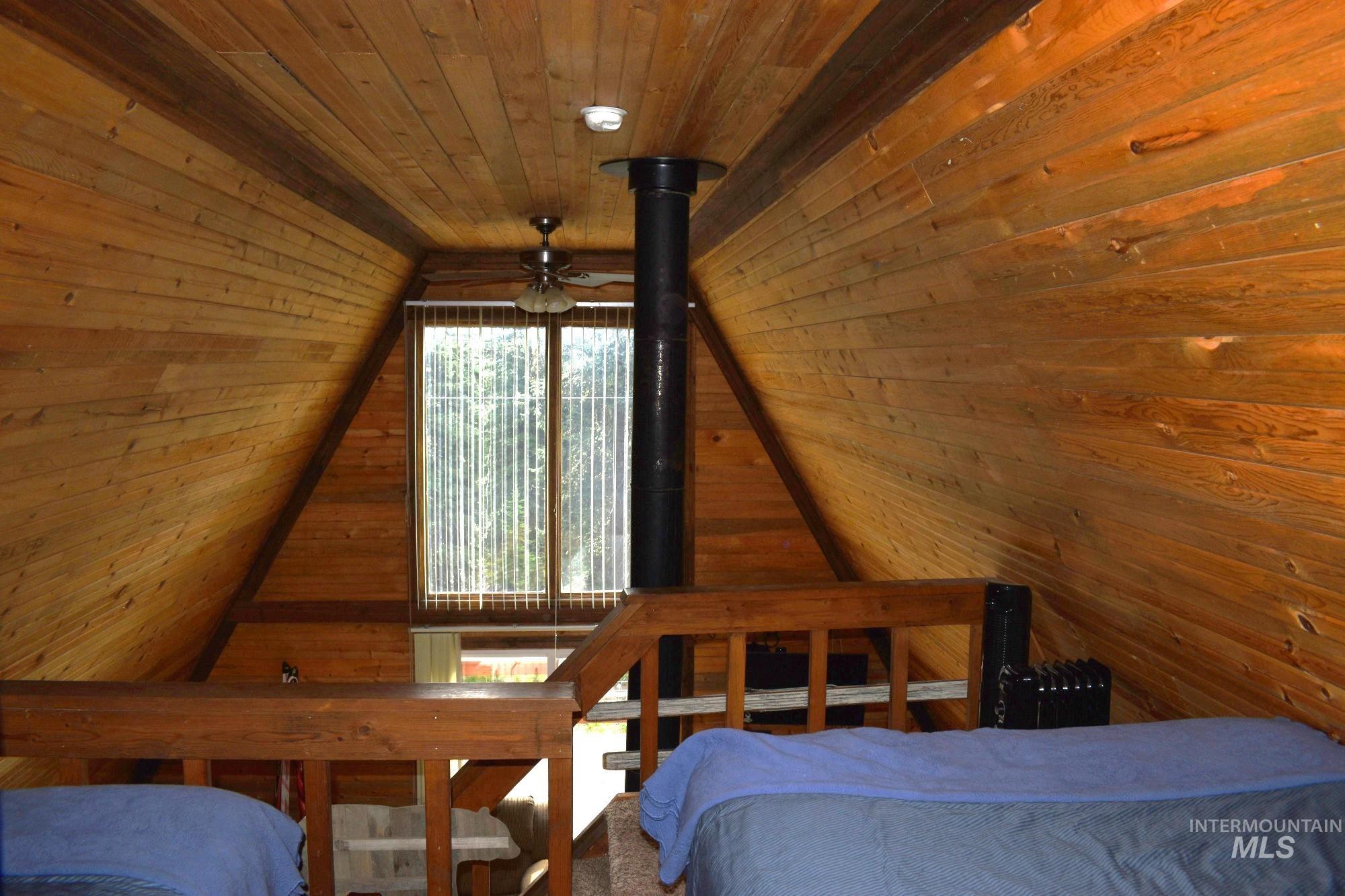 Wood-paneled interior featuring a vaulted ceiling and exposed wood beams