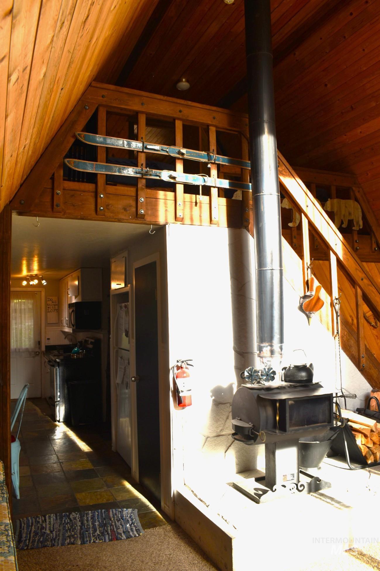 Wood-paneled interior featuring a prominent wood-burning stove with a stovepipe