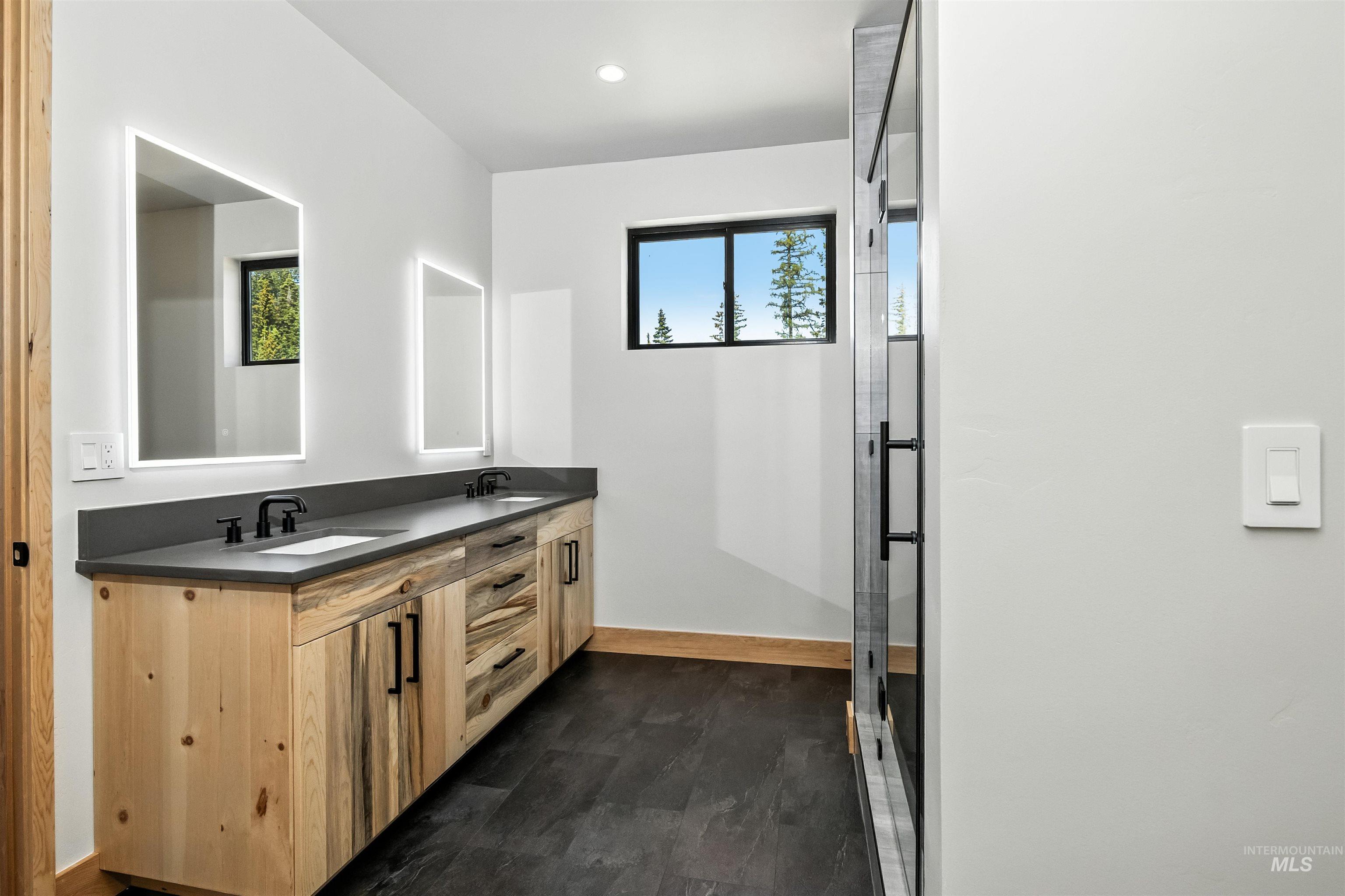 Bathroom featuring double vanity, a stall shower, recessed lighting, and dark wood finished floors