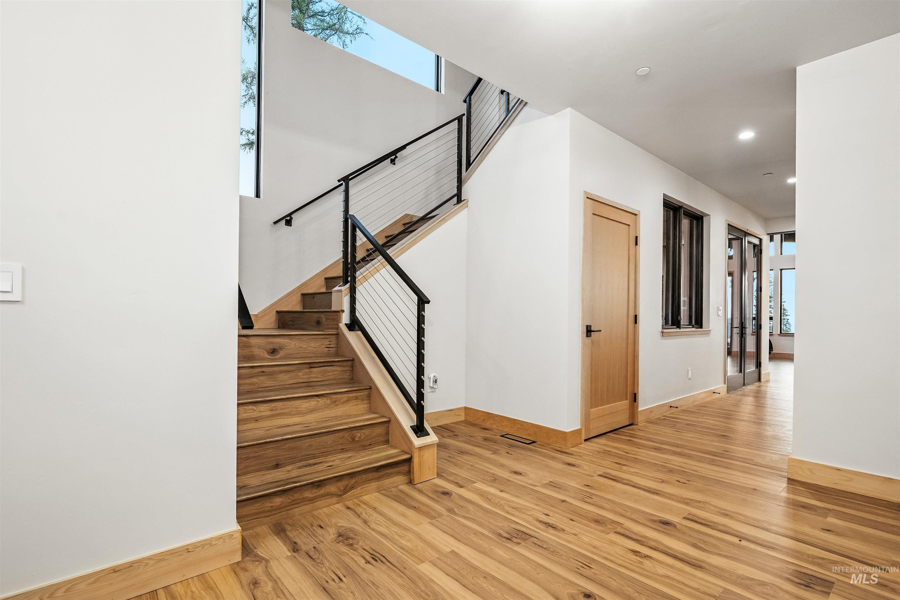 Staircase featuring wood finished floors and recessed lighting