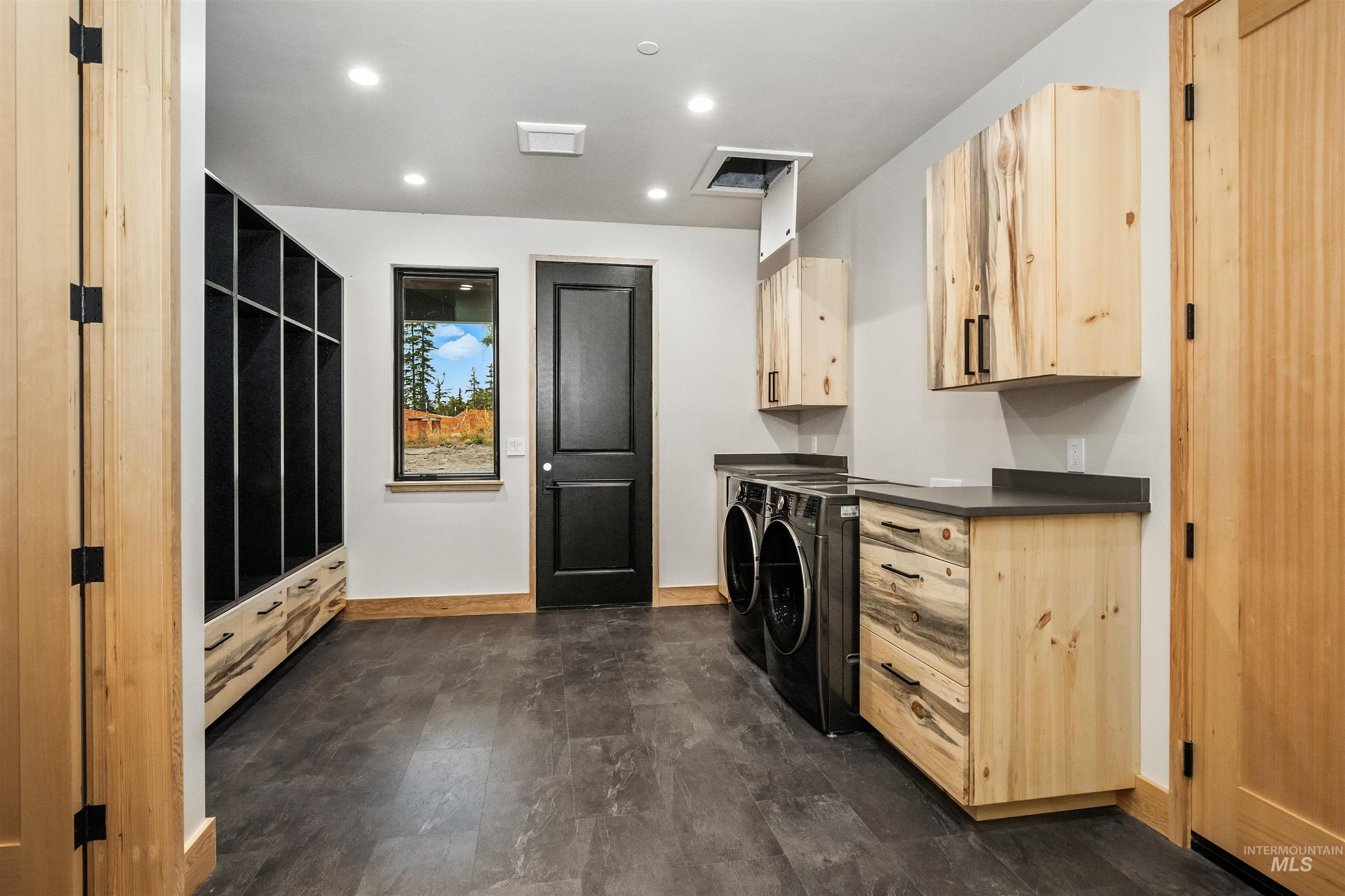 Laundry area with washing machine and dryer, recessed lighting, and cabinet space