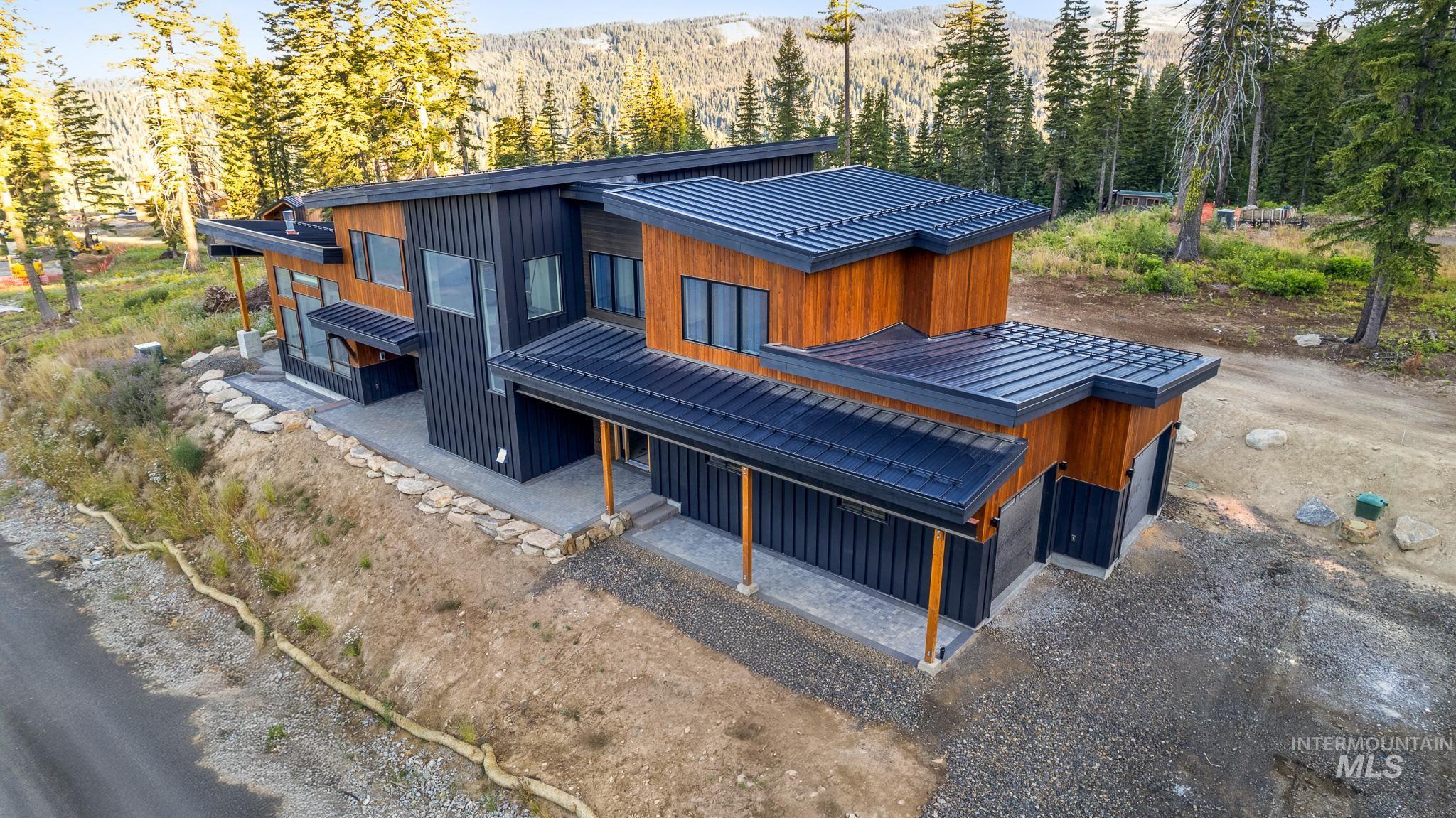Rear view of house featuring a view of trees and a metal roof