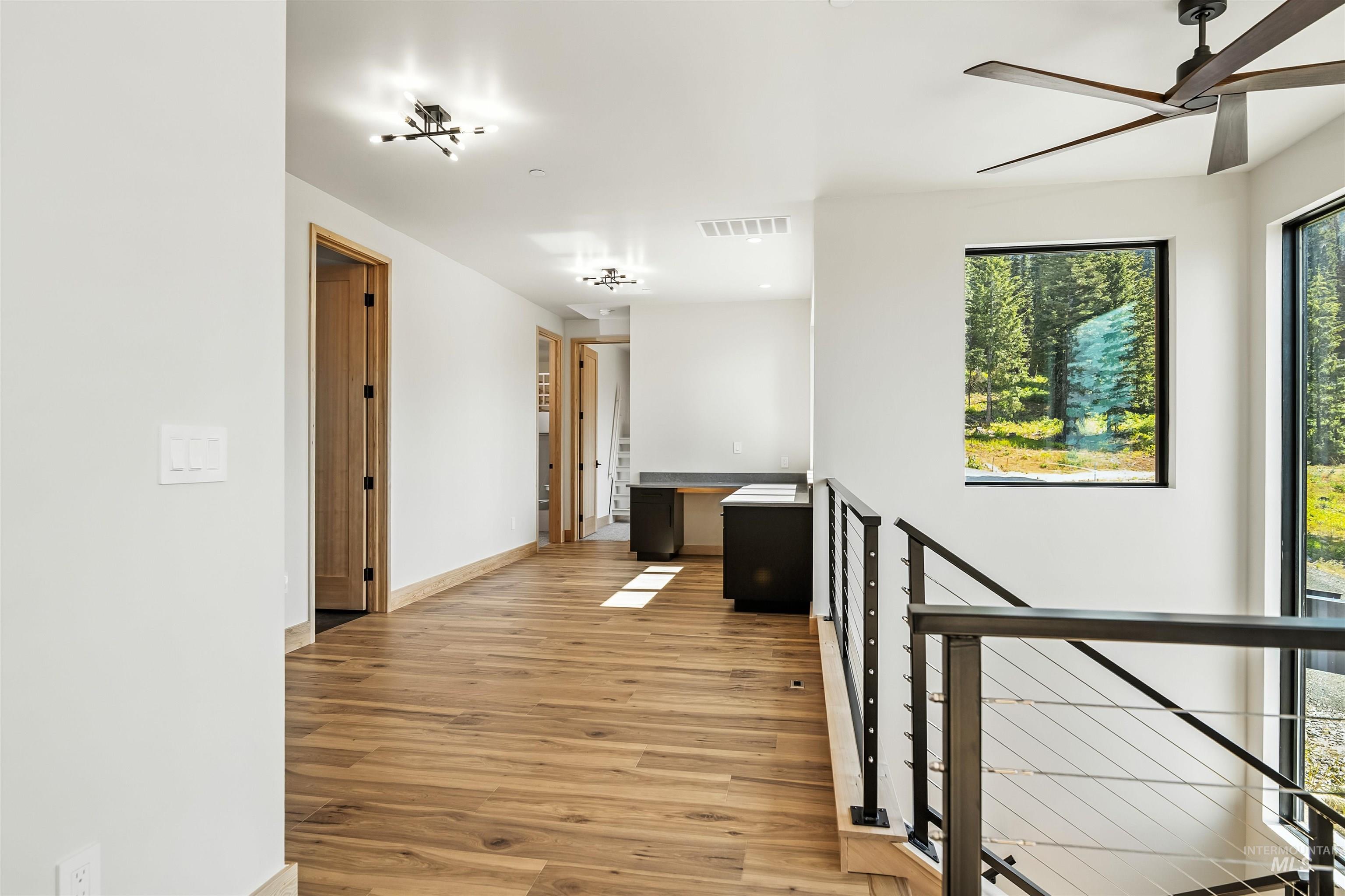 Corridor with an upstairs landing and light wood-style flooring