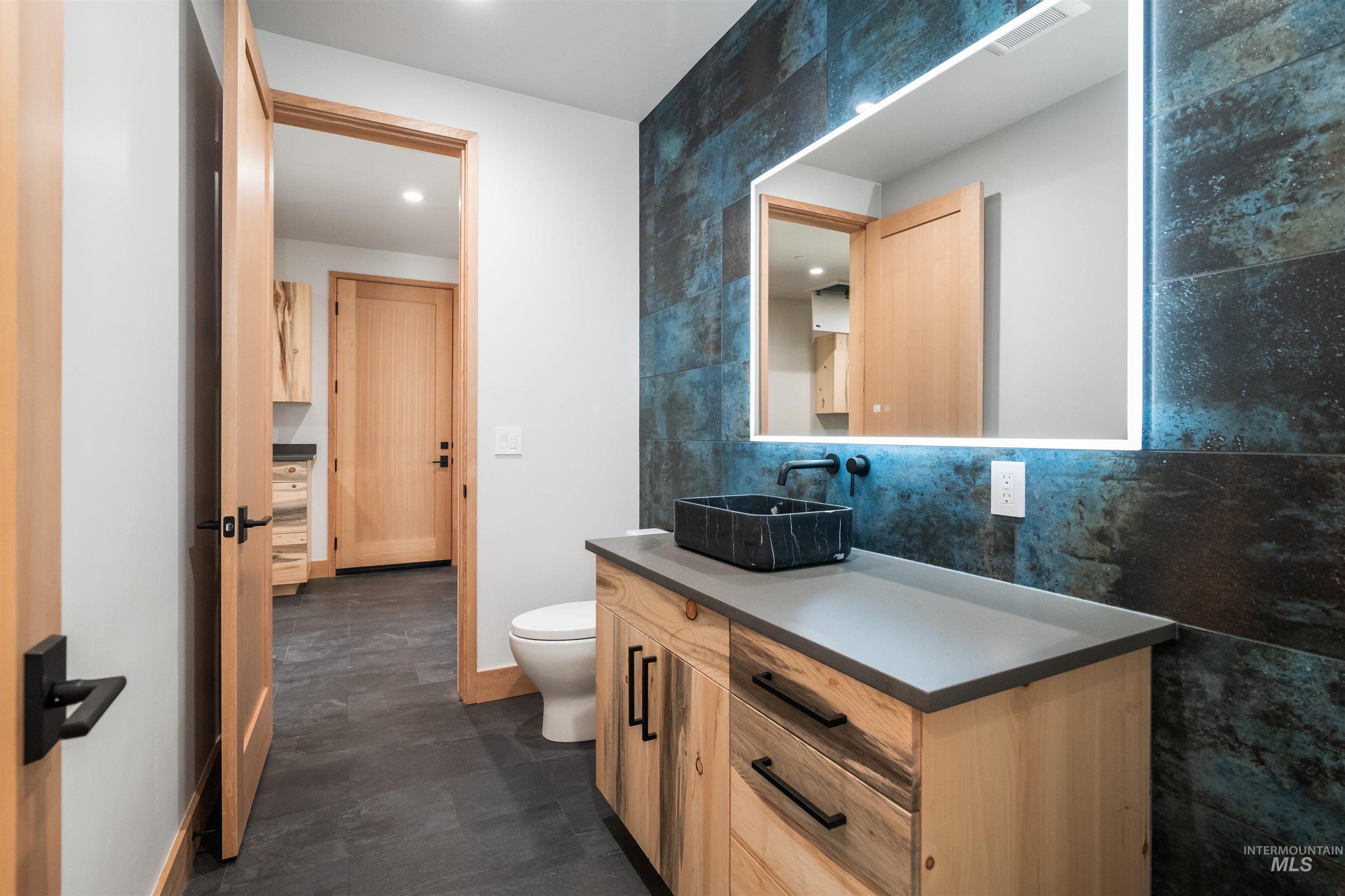Bathroom featuring vanity, tile walls, and recessed lighting