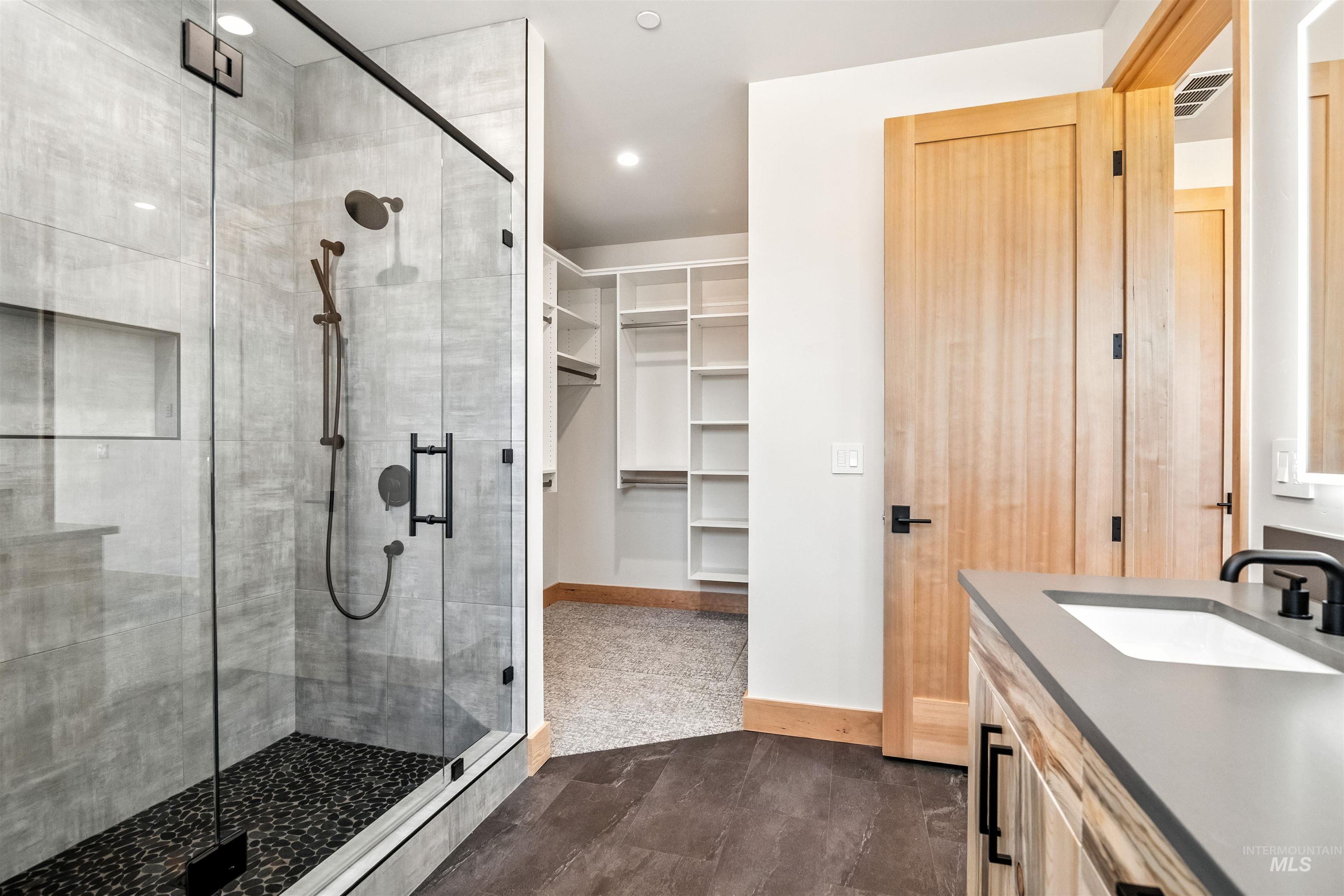 Bathroom with vanity, a stall shower, recessed lighting, a spacious closet, and dark tile patterned floors