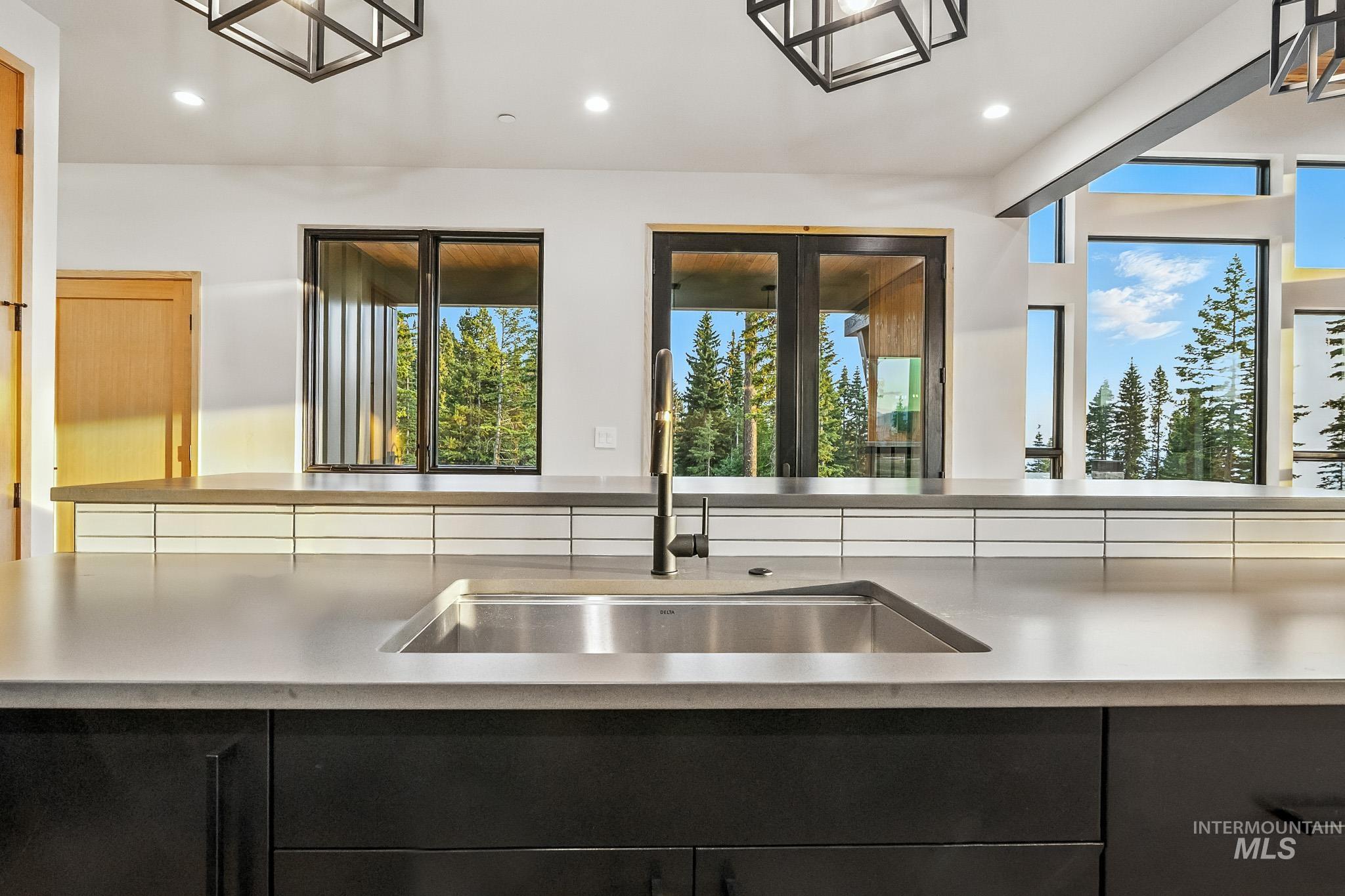 Kitchen with dark cabinetry, light countertops, recessed lighting, and pendant lighting