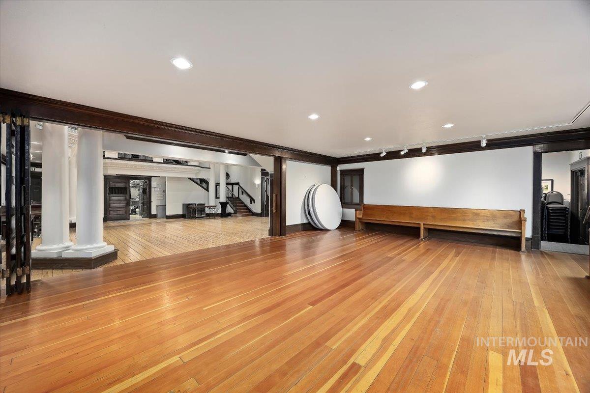 Exercise area with light wood finished floors, recessed lighting, and ornamental molding