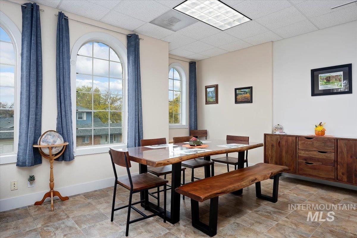 Dining area with a drop ceiling and stone finish flooring
