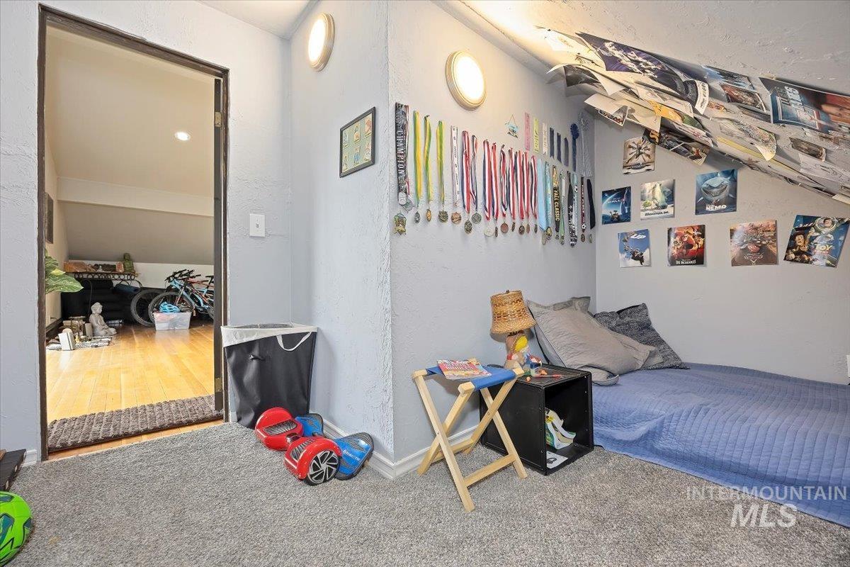 Carpeted bedroom with a textured wall and baseboards