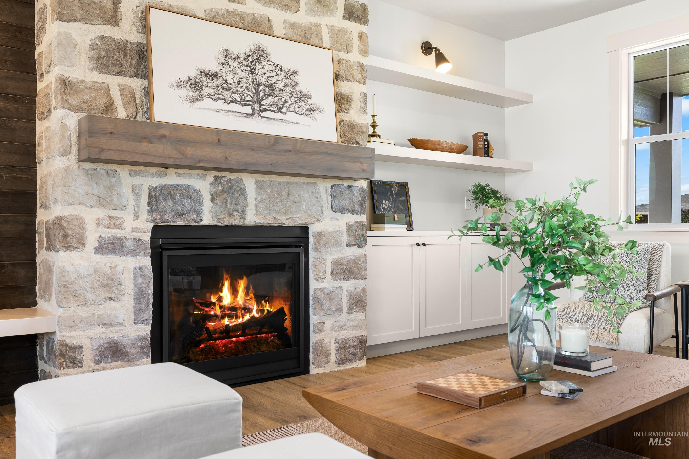 Detailed view of wood finished floors and a stone fireplace