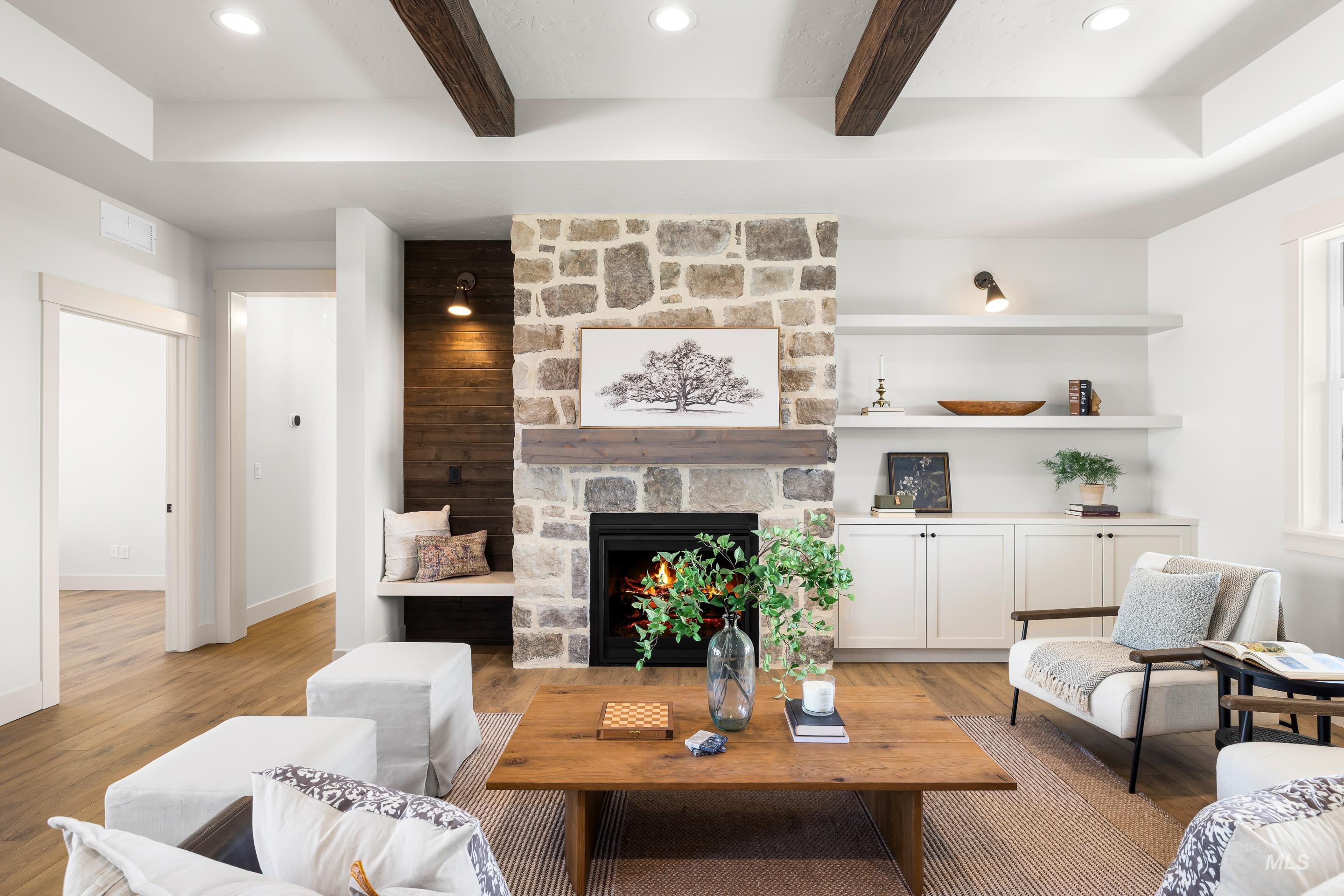 Living room with beamed ceiling, light wood finished floors, a fireplace, and recessed lighting
