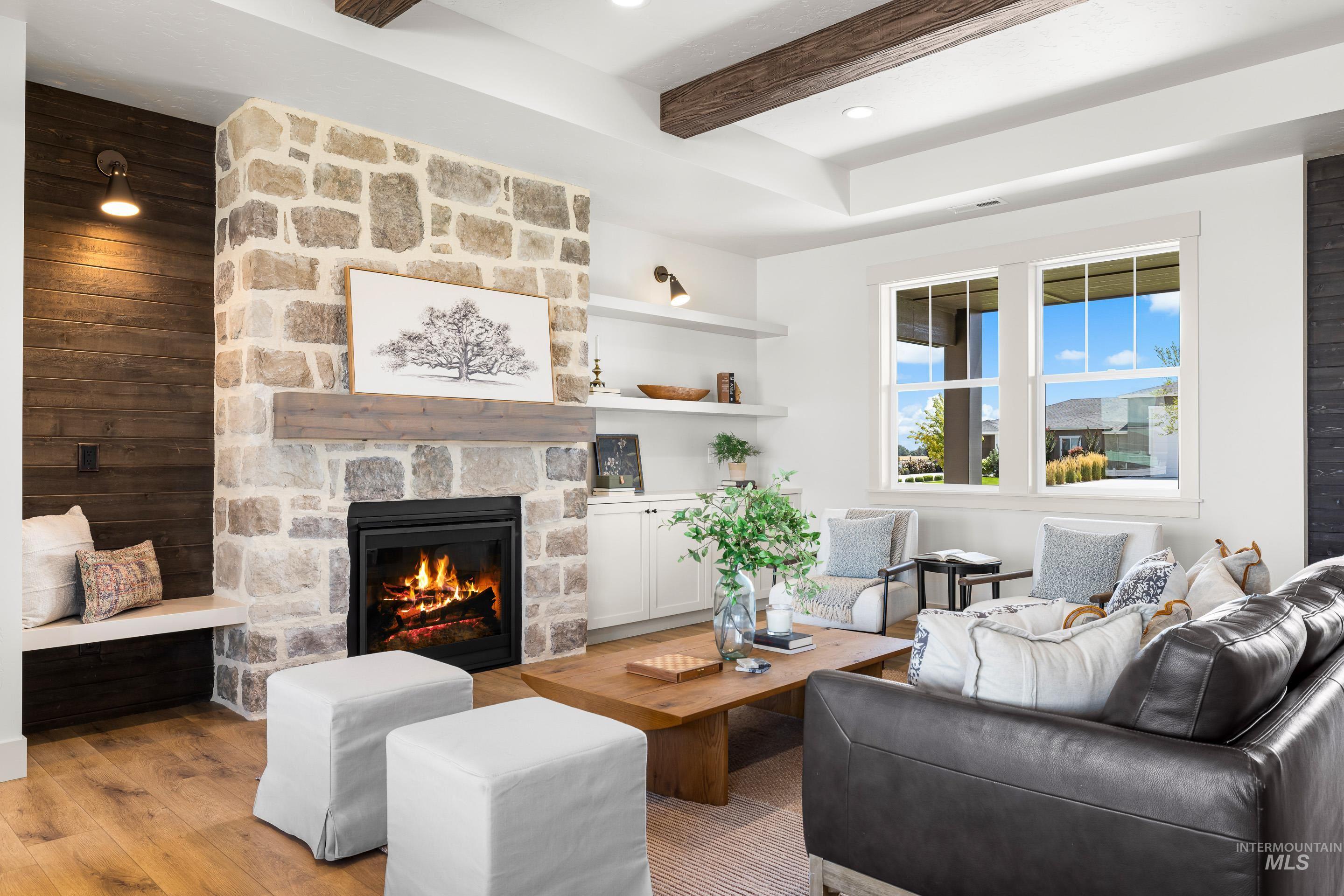 Living area with beam ceiling, light wood-style floors, and a fireplace