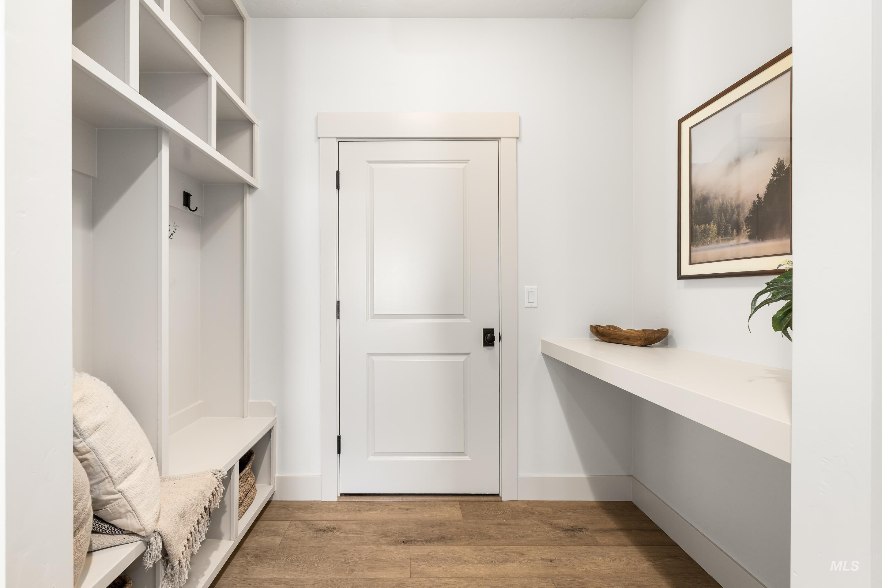 Mudroom featuring light wood-type flooring and built in desk