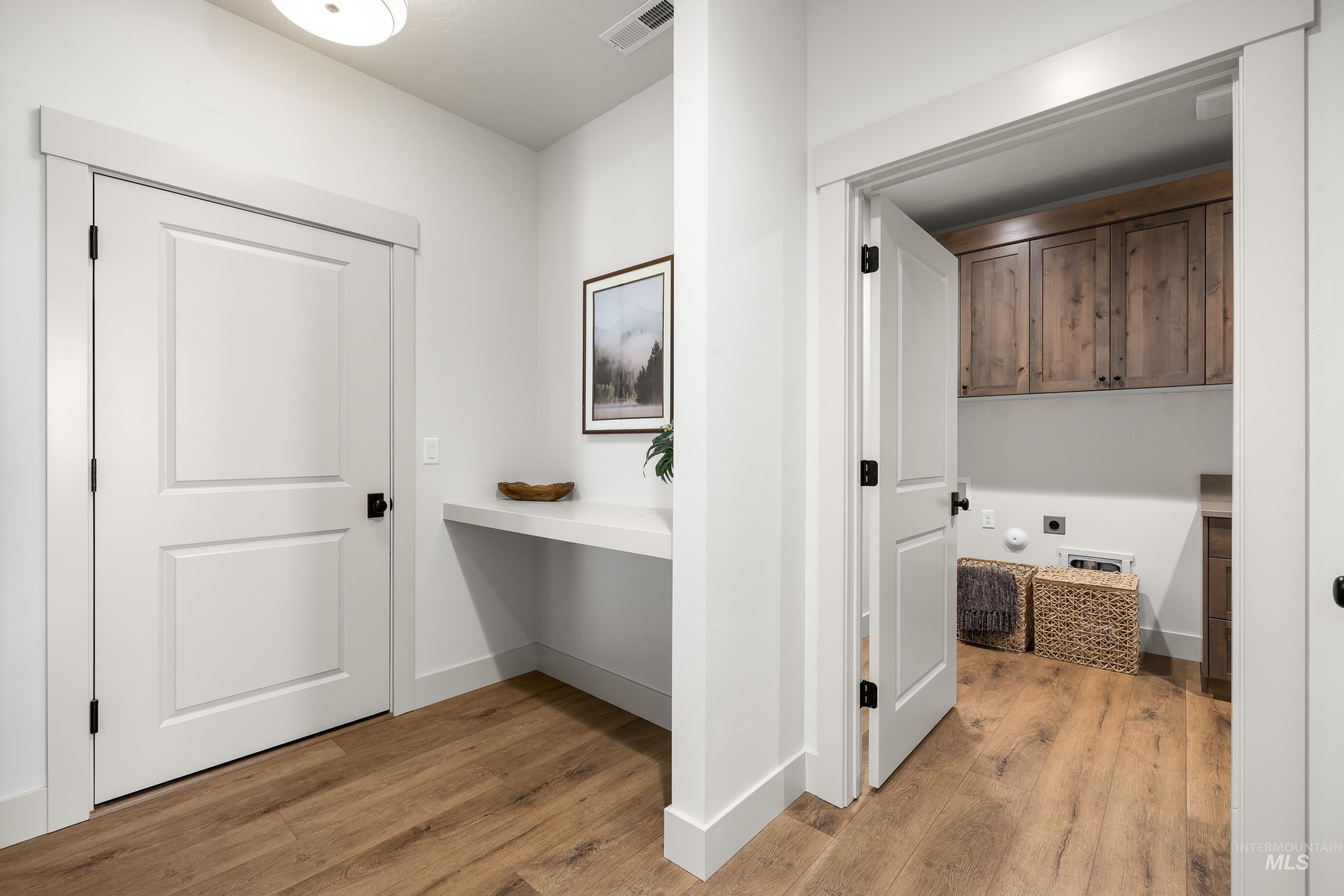 Hall with an office area and light wood-style flooring