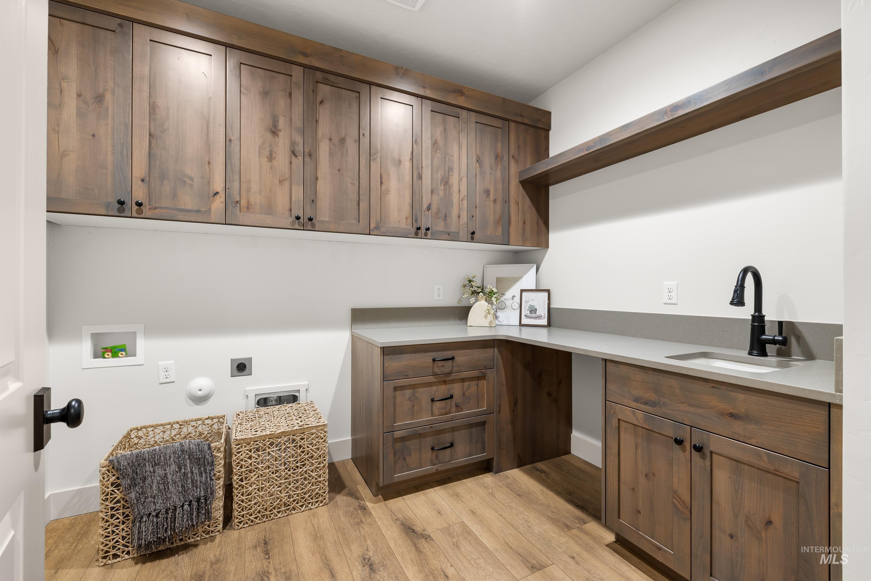 Laundry room with hookup for an electric dryer, cabinet space, washer hookup, light wood-style flooring, and gas dryer hookup