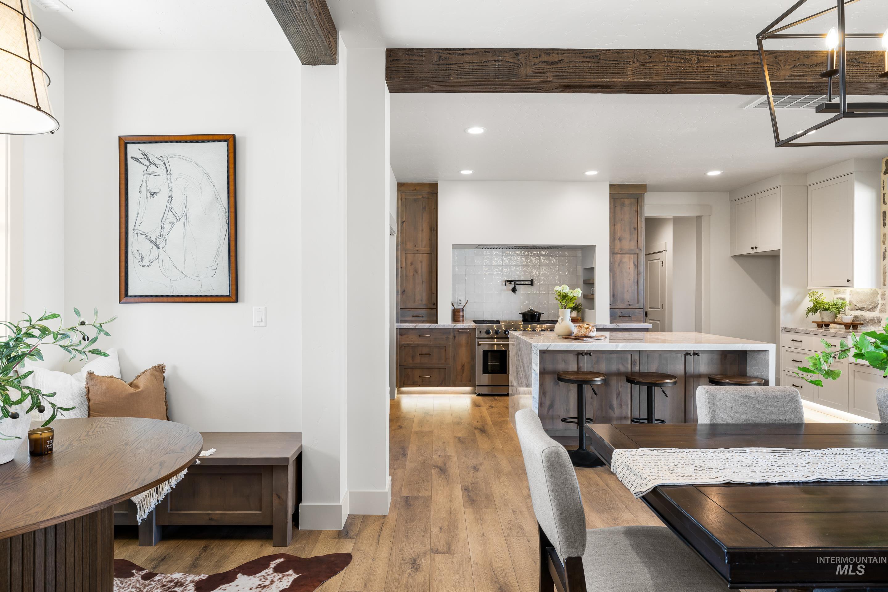 Dining room featuring light wood-style floors, beamed ceiling, and recessed lighting