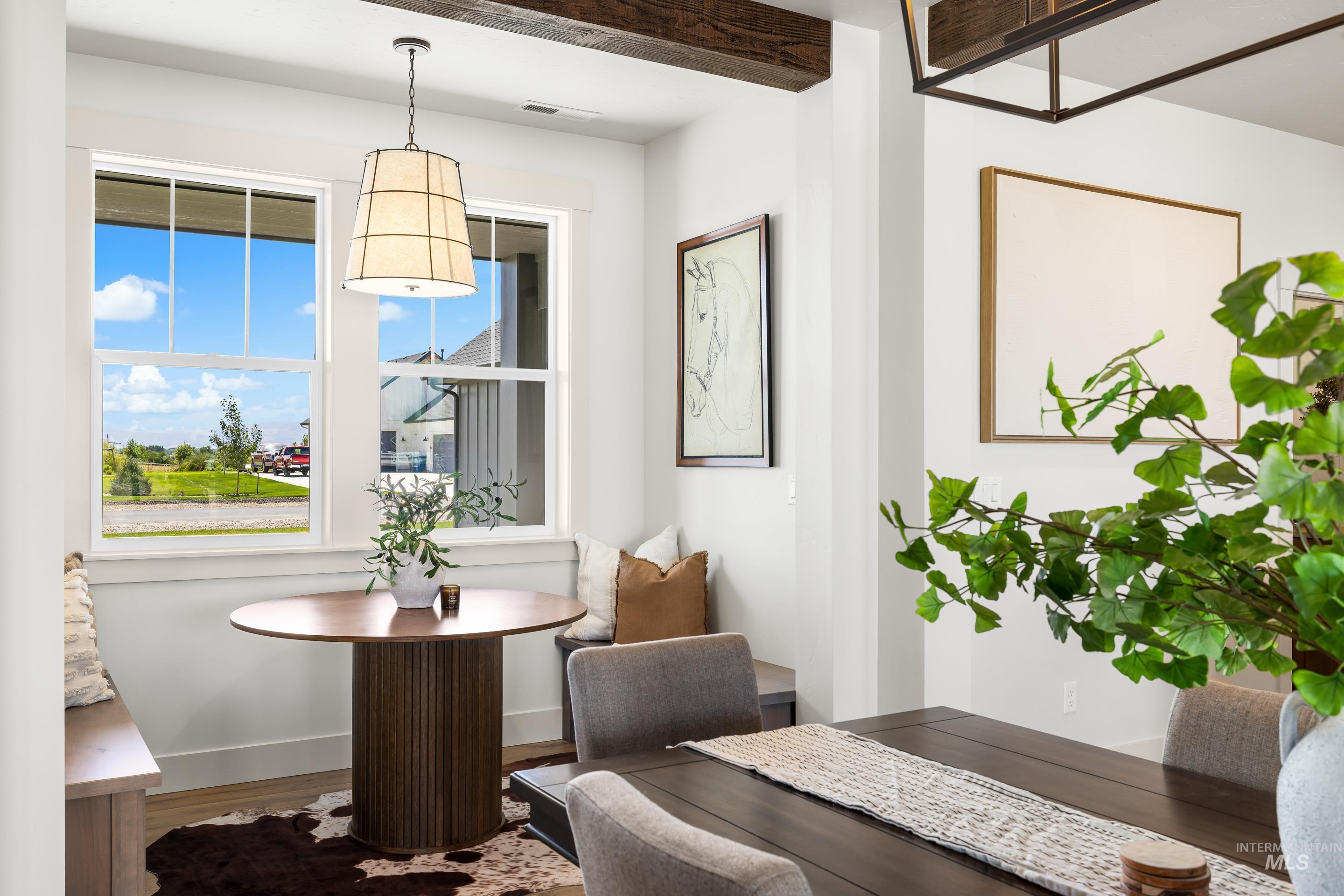Dining room with wood finished floors and beamed ceiling