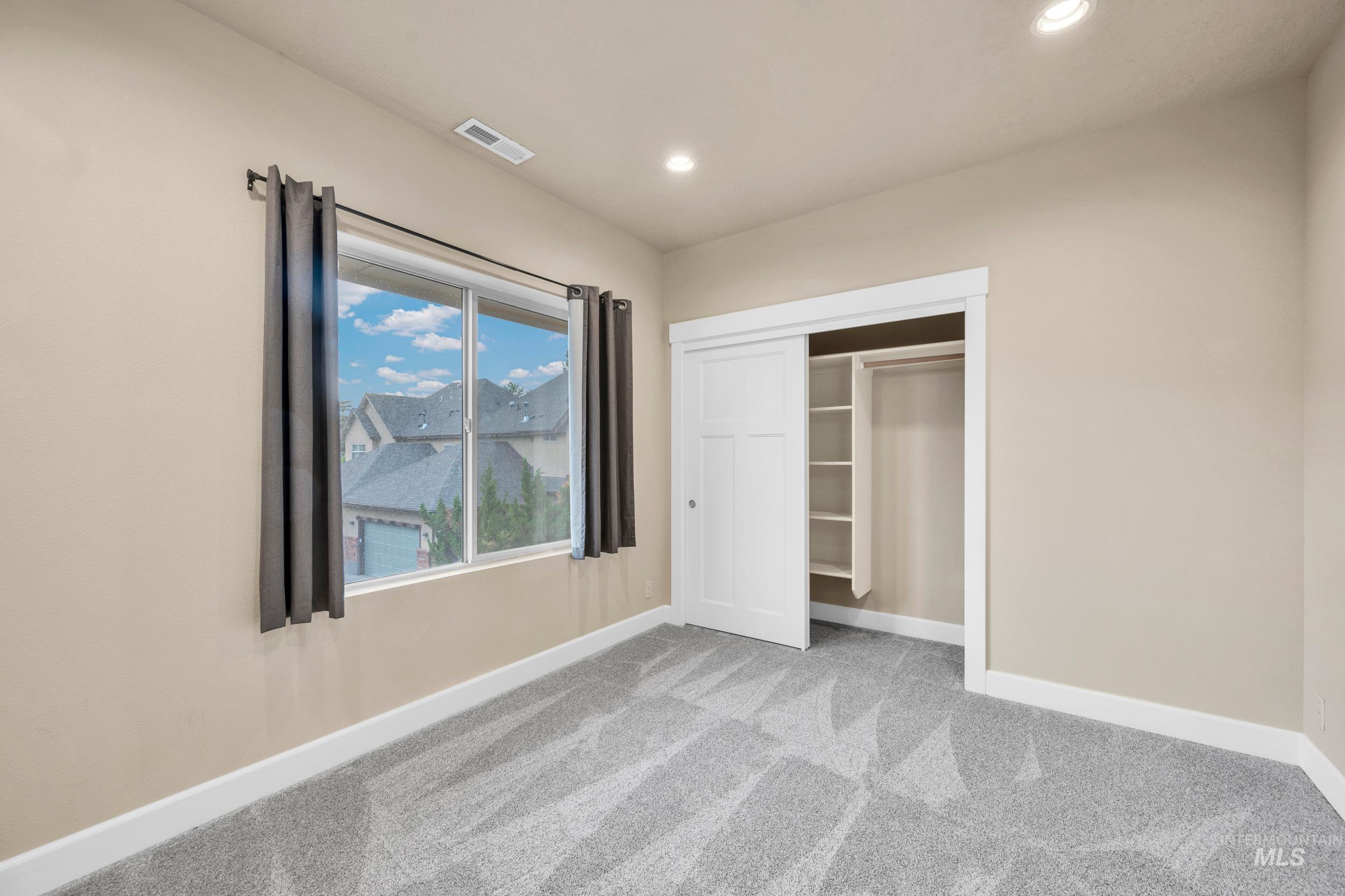 Unfurnished bedroom with carpet, a closet, and recessed lighting