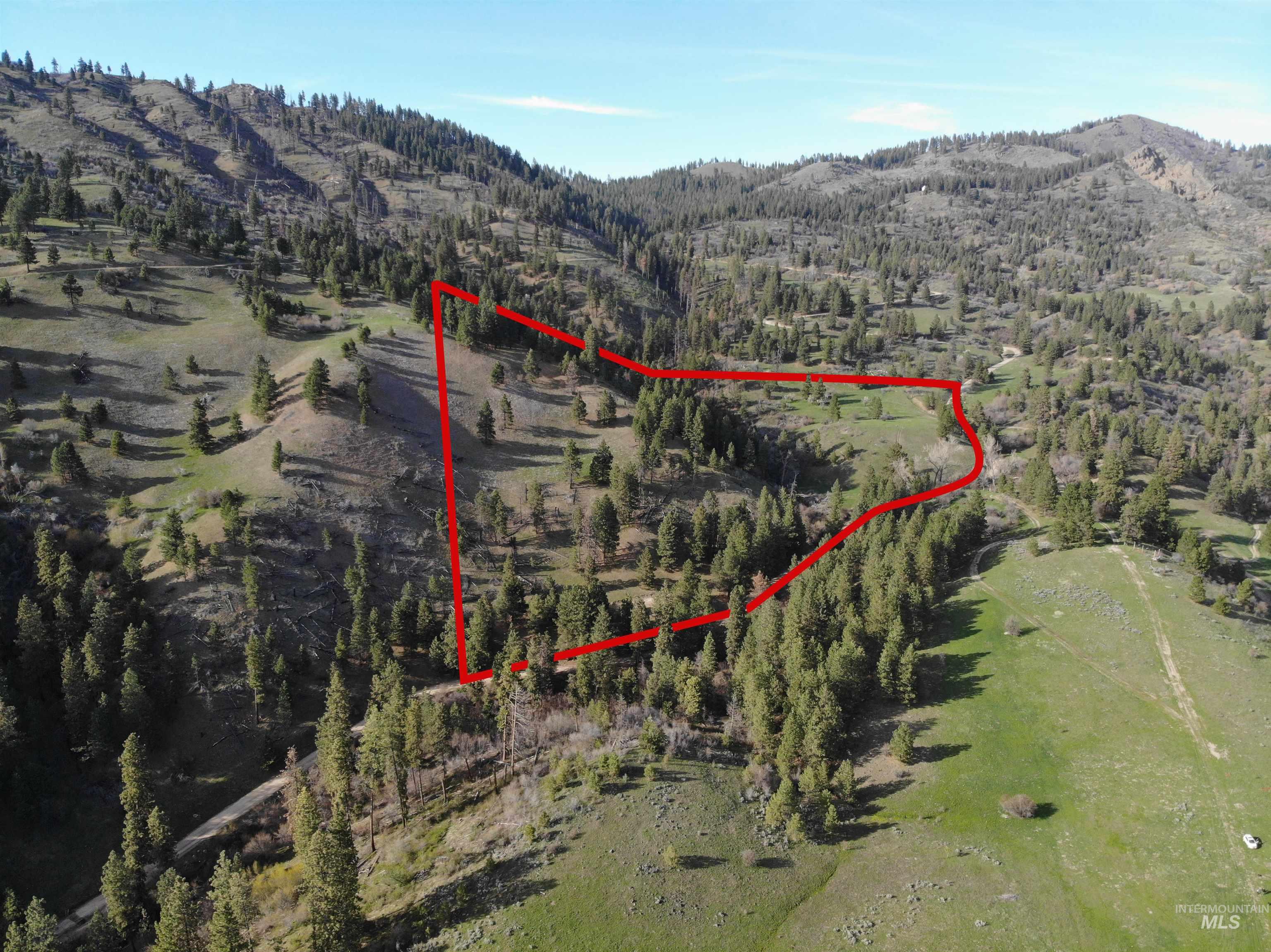 Aerial view of property's location with property boundaries highlighted and a mountainous background