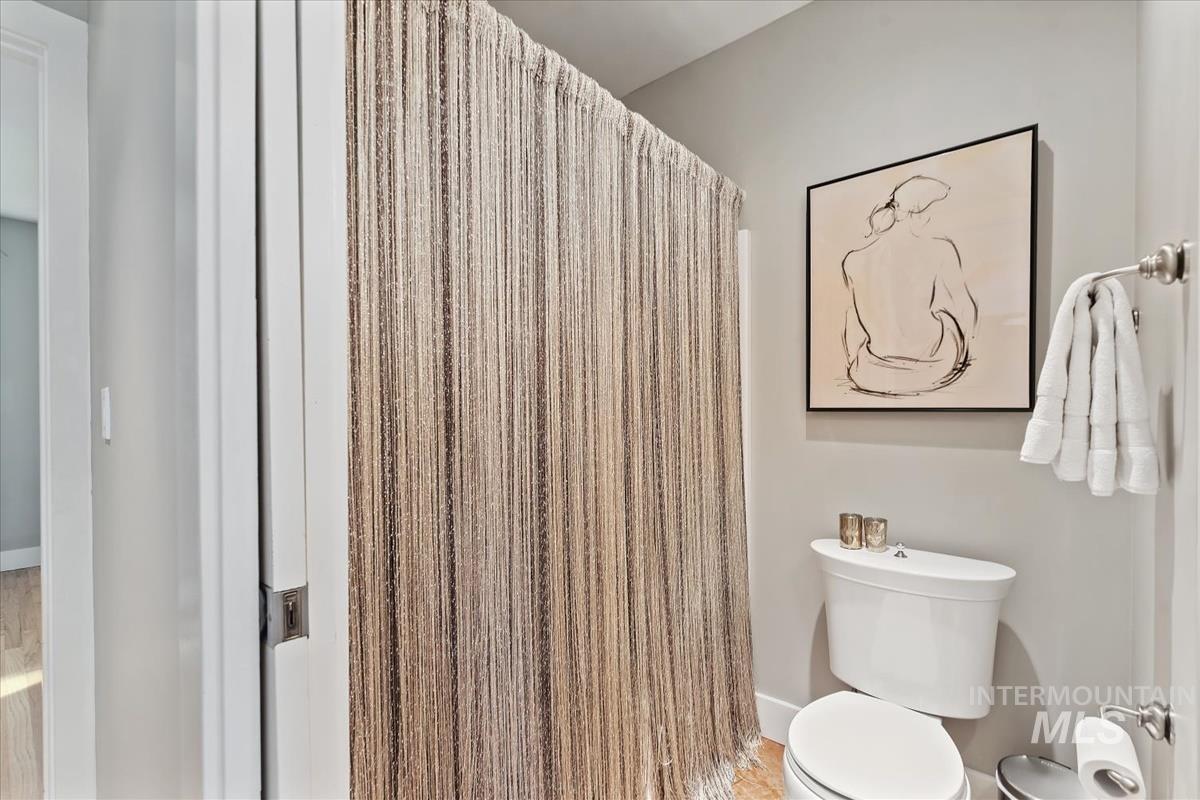 Bathroom with a shower with shower curtain and toilet