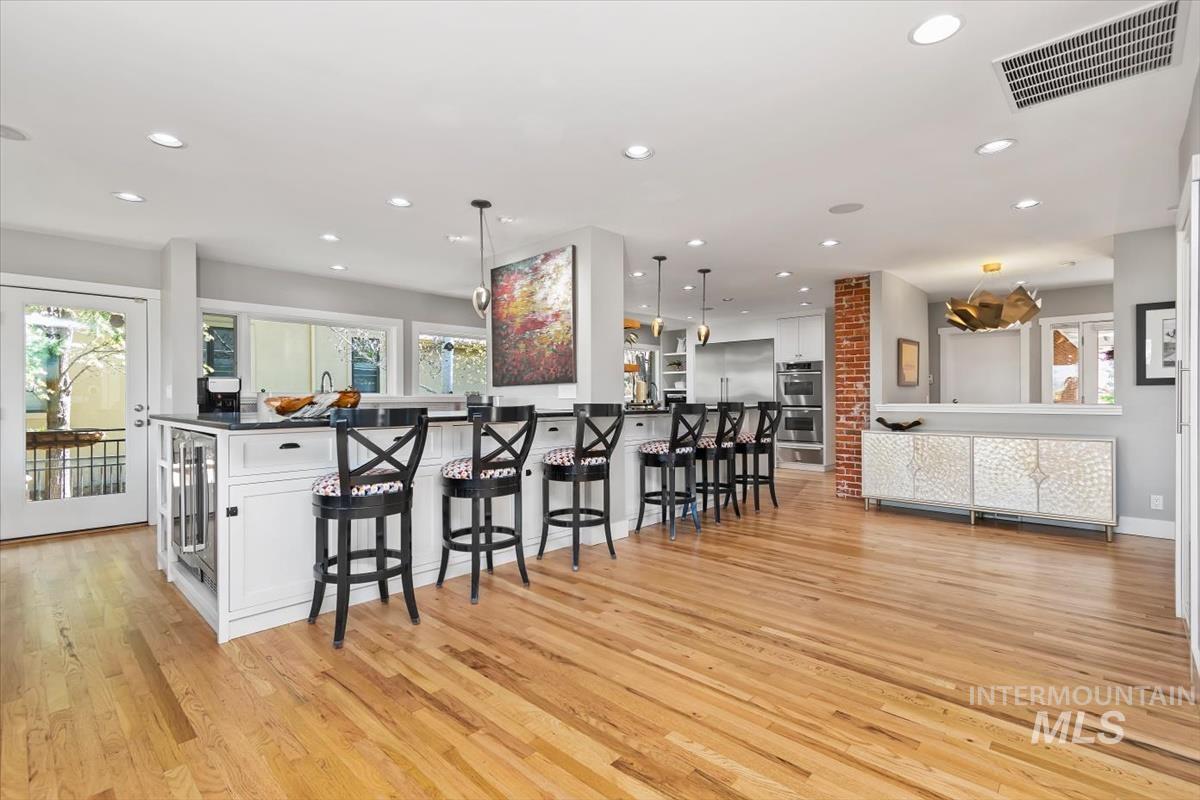 Spacious kitchen featuring a large island with seating, integrated beverage cooler, and dark countertop