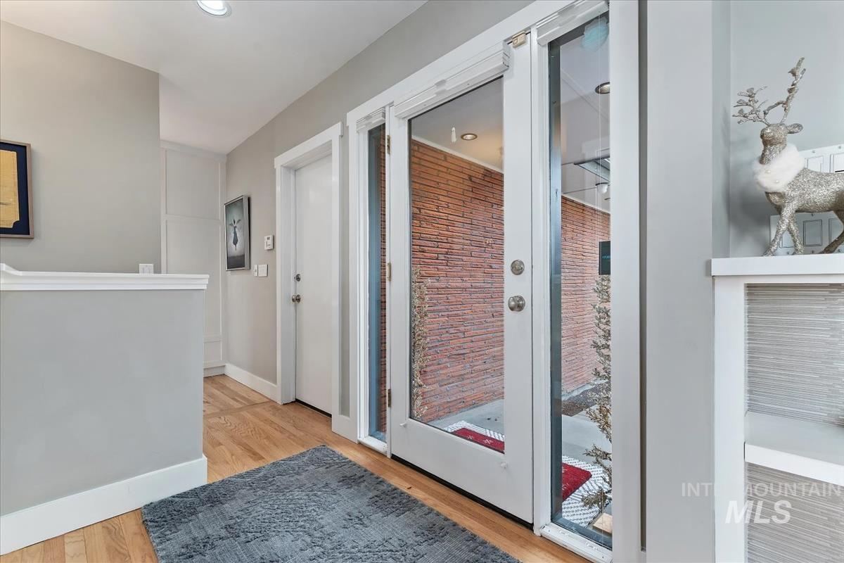 Doorway with wood finished floors and recessed lighting