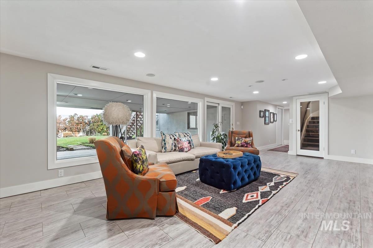 Living area with stairs, recessed lighting, and wood tiled floors