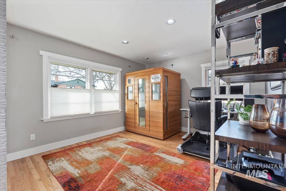 Office space with a relaxing sauna, light wood finished floors, and recessed lighting