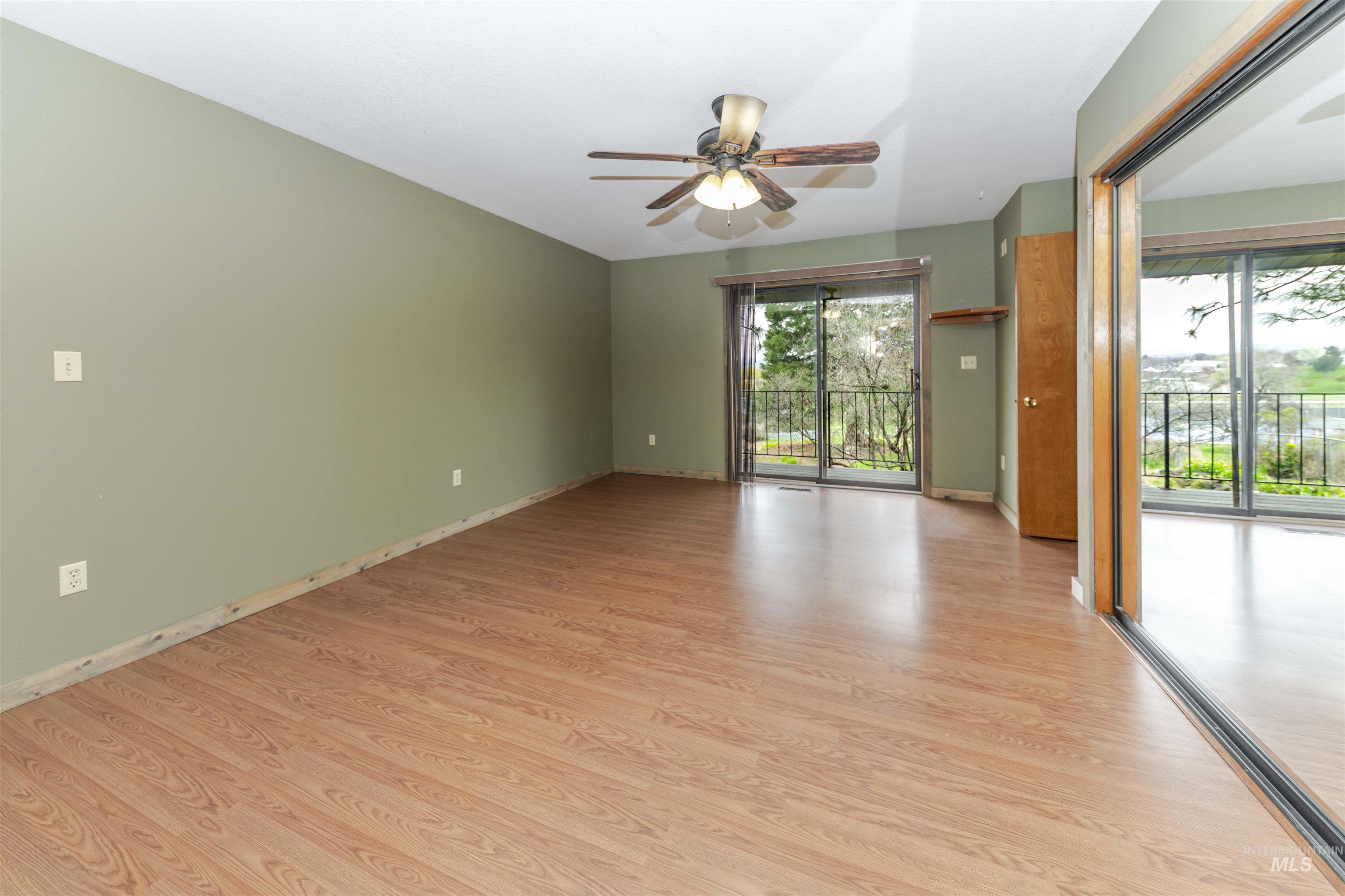 Primary Bedroom with light wood-style floors and ceiling fan