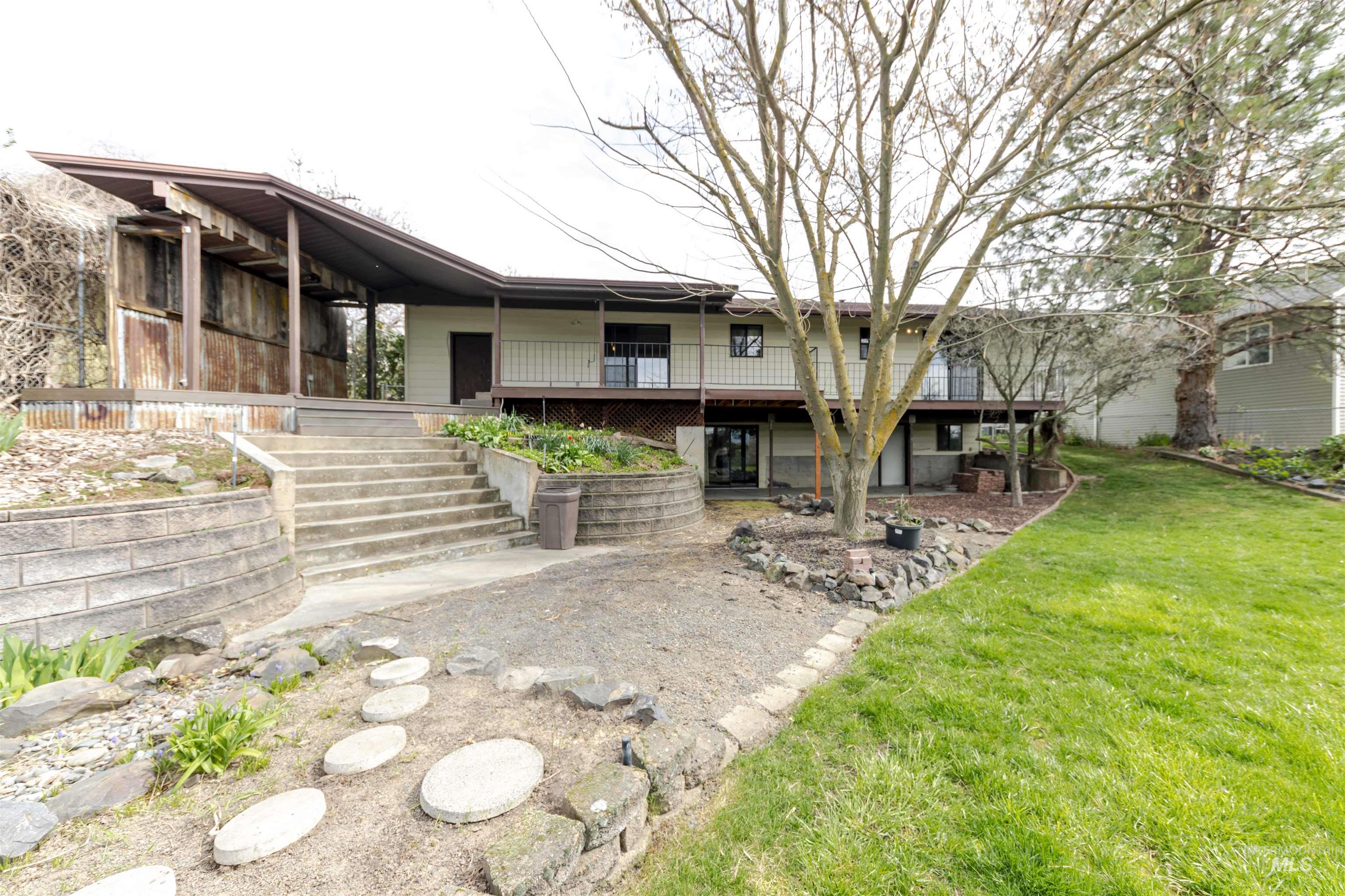 Rear view of property featuring a lawn and a wooden deck